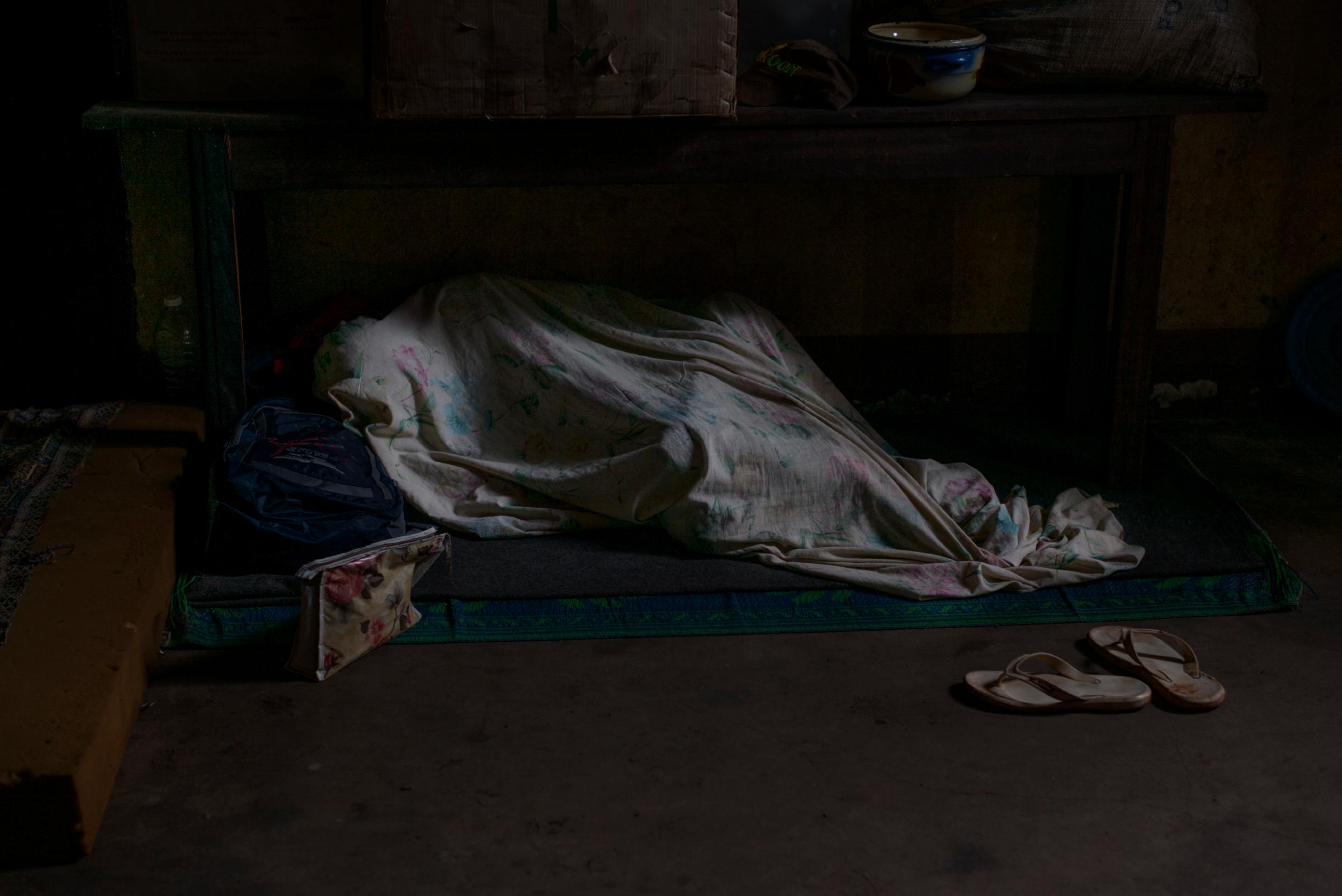 A Muslim man sleeps under a sheet at a church in Carnot, where he is taking refuge with other Muslims following violence by antibalaka, Oct. 21, 2015.