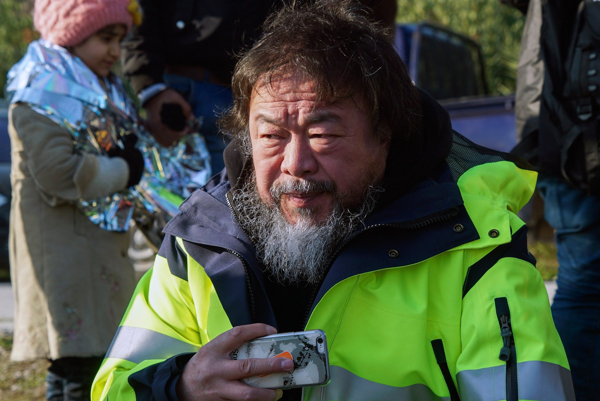 Chinese activist and artist Ai Weiwei assists refugees and migrants after their arrival from the Turkish coast to a beach on the Greek island of Lesbos, Jan. 28, 2016.