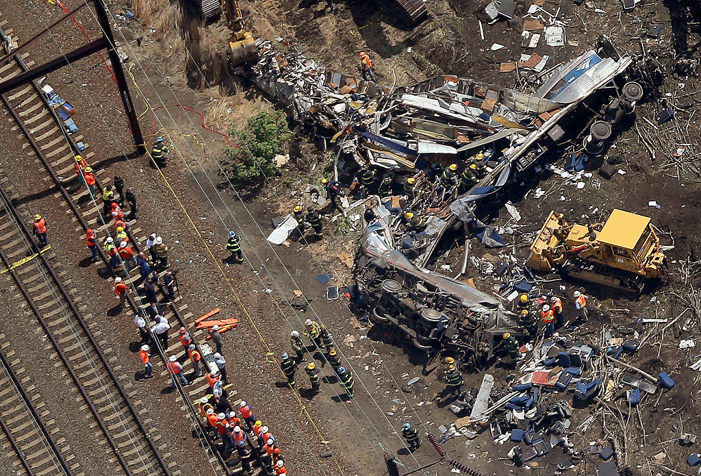 Investigators and first responders work near the wreckage of an Amtrak passenger train carrying more than 200 passengers from Washington, DC to New York that derailed May 13, 2015 in north Philadelphia, Pennsylvania.