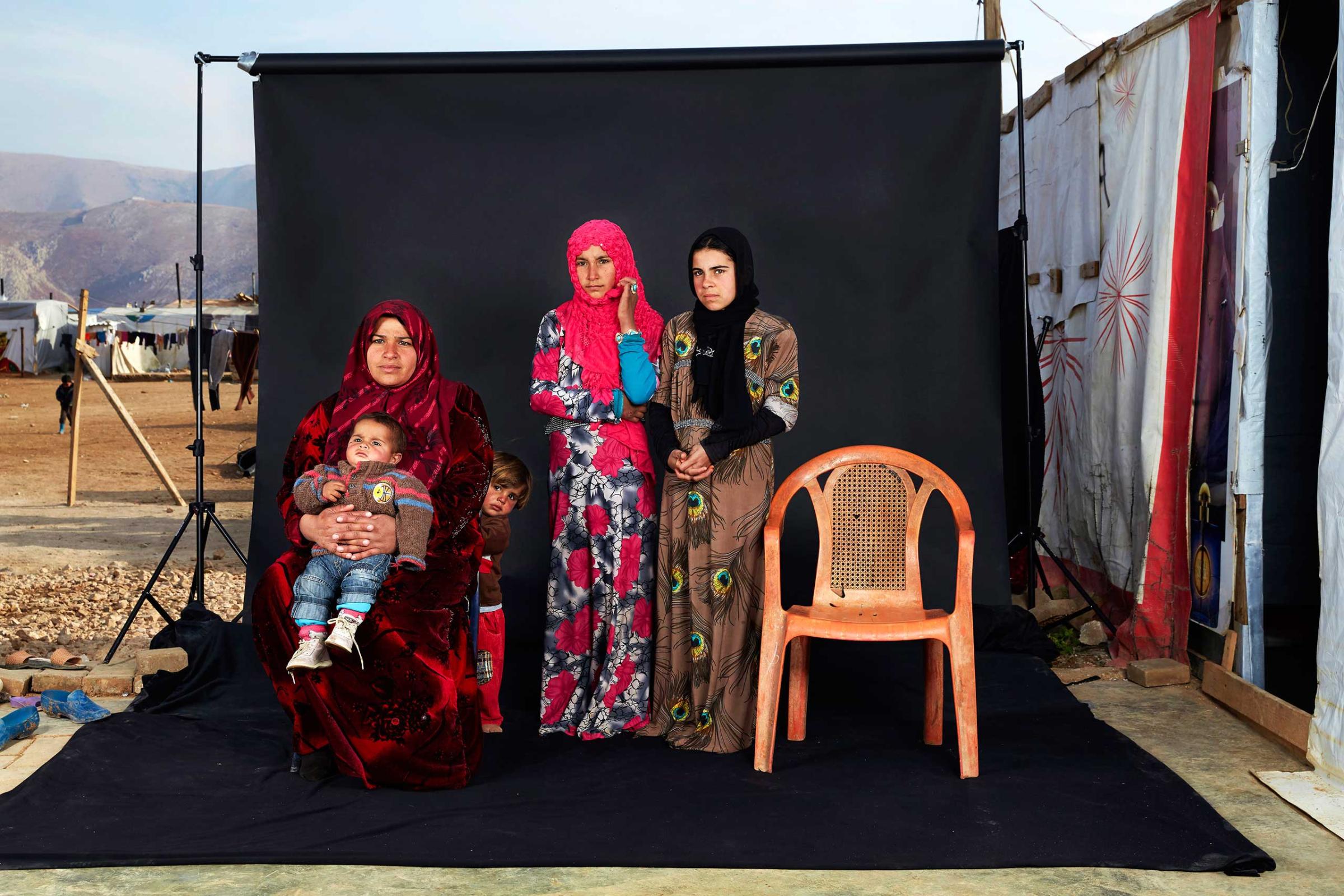 People, 3rd prize singles. Portrait of a Syrian refugee family in a camp in Bekaa Valley, Lebanon, on 15 December 2015. The empty chair in the photograph represents a family member who has either died in the war or whose whereabouts are unknown.