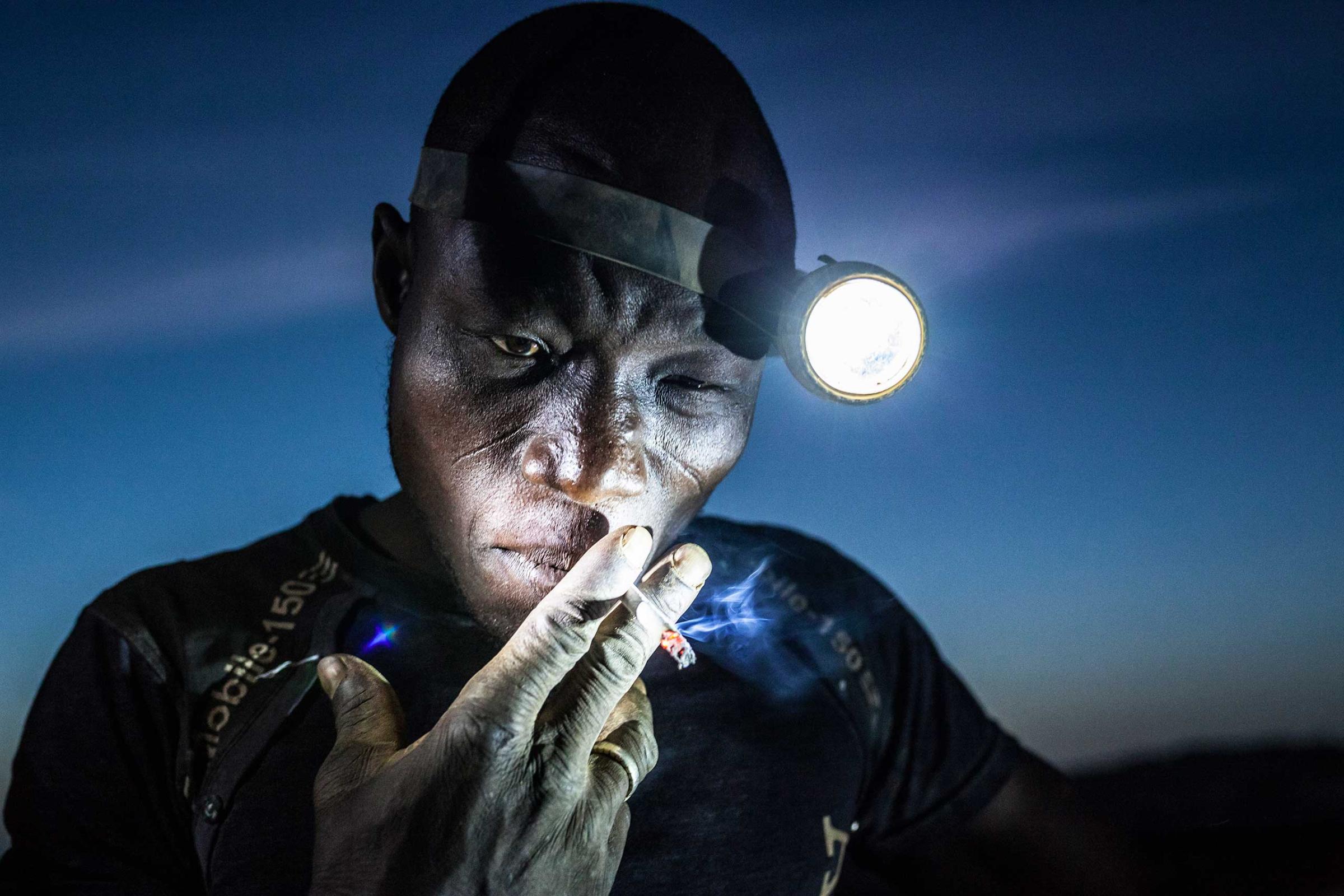 People, 2nd prize singles. A mine worker takes a smoke break before going back into the pit. Miners in Bani face harsh conditions and exposure to toxic chemicals and heavy metals. Image taken in Bani, Burkina Faso, on Nov. 20, 2015.
