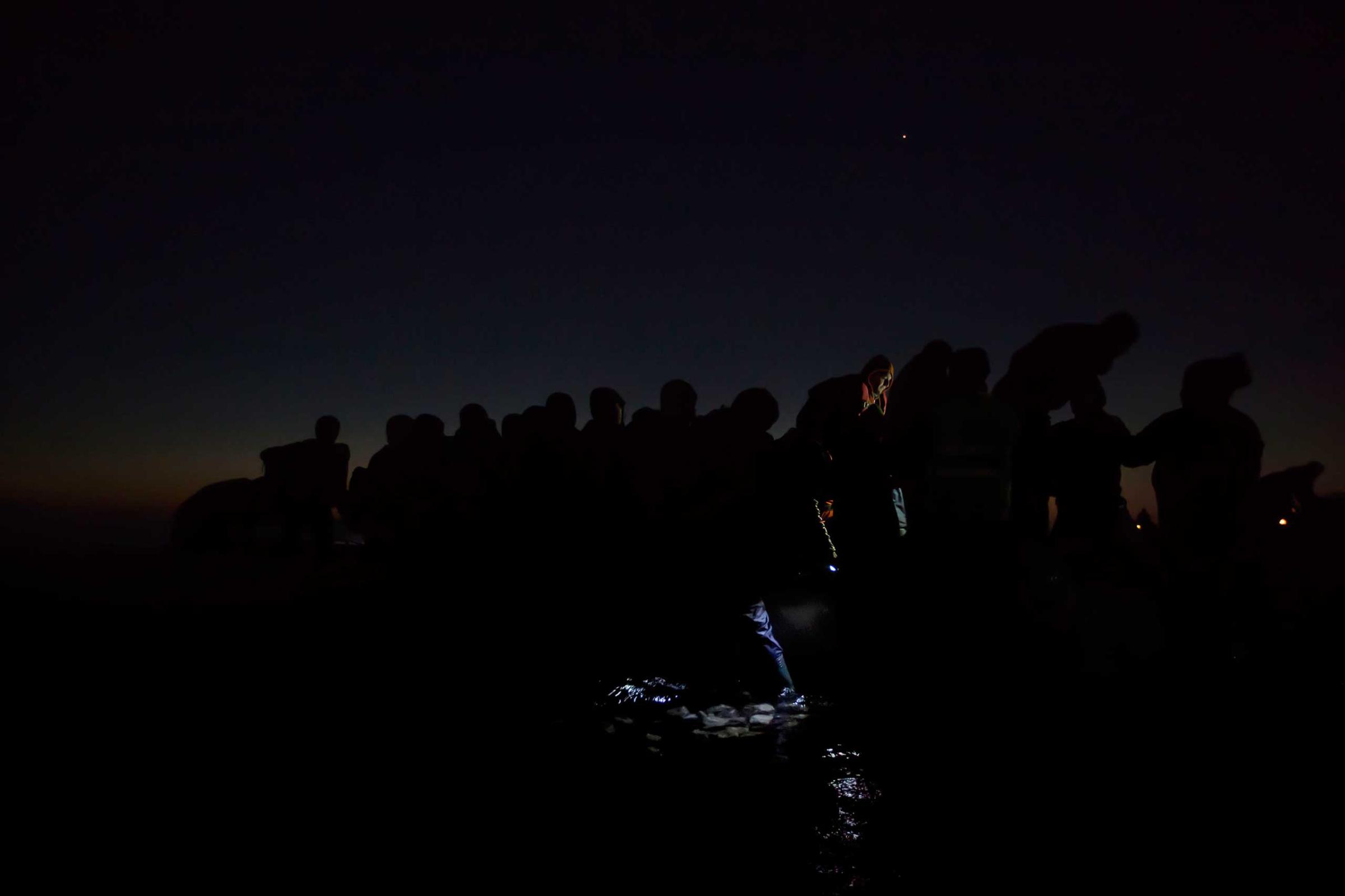 General News, 2nd prize singles. Refugees travel in darkness through Europe to avoid detection; Lesbos, Greece, Dec. 6, 2015.