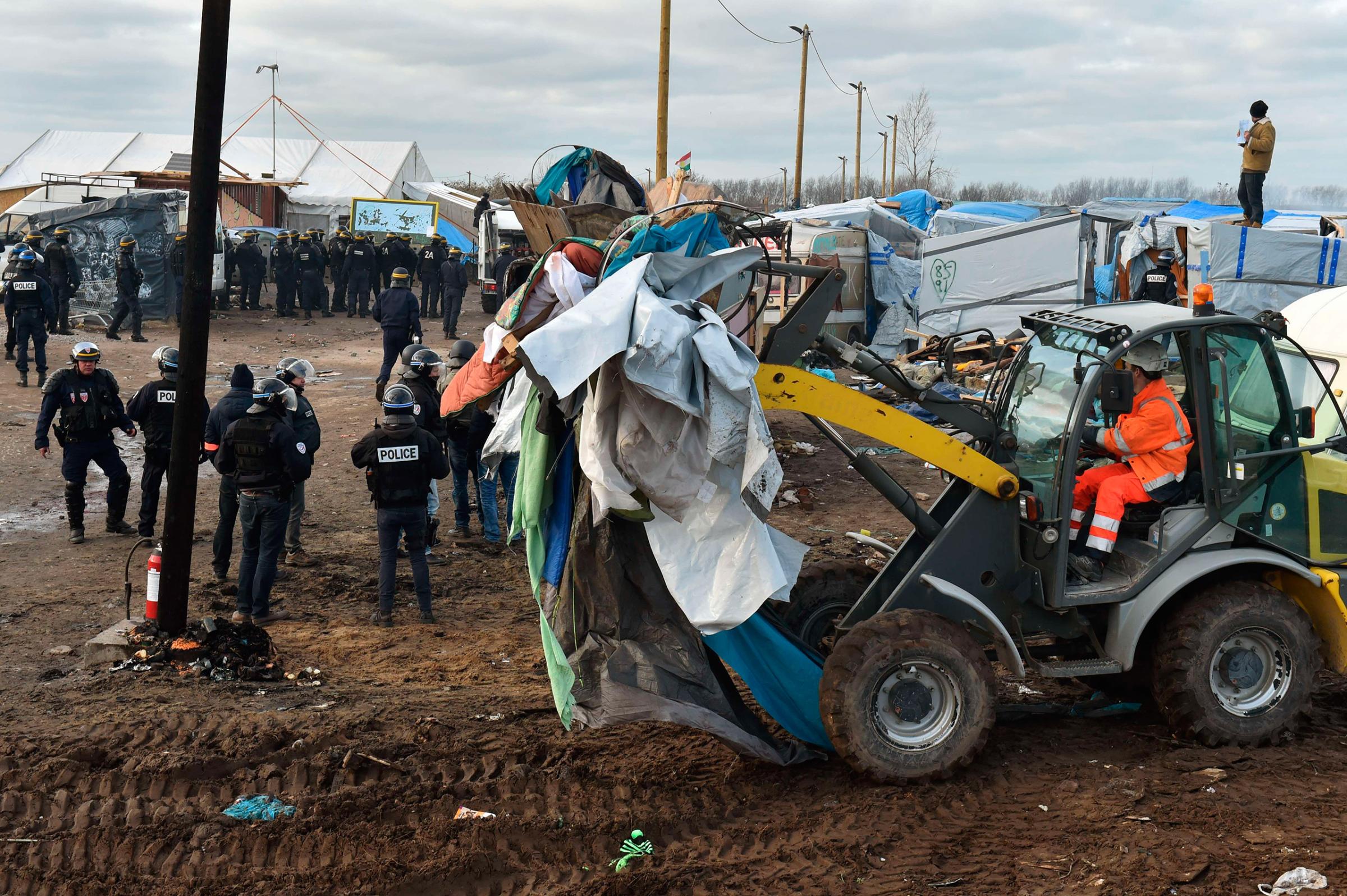 A bulldozer dismantles shelters in the "Jungle" migrant camp in the northern port city of Calais, France, Feb. 29, 2016.