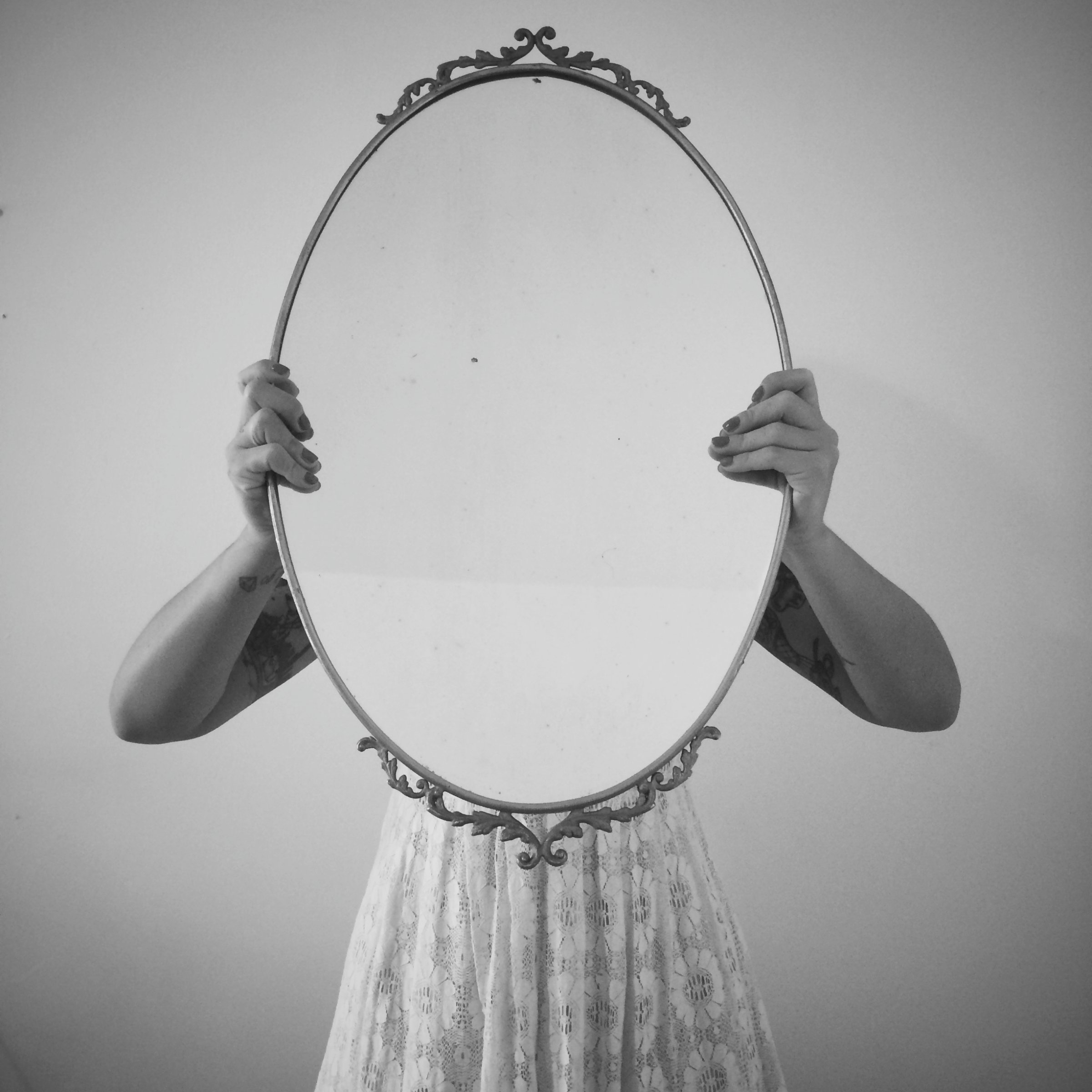 Woman Holding Mirror Against Wall