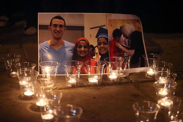 Candles are seen as a group of demonstrators gather in front of  American Embassy in Amman to protest against the Chapel Hill shooting, in Amman, Jordan on Feb. 16, 2015.