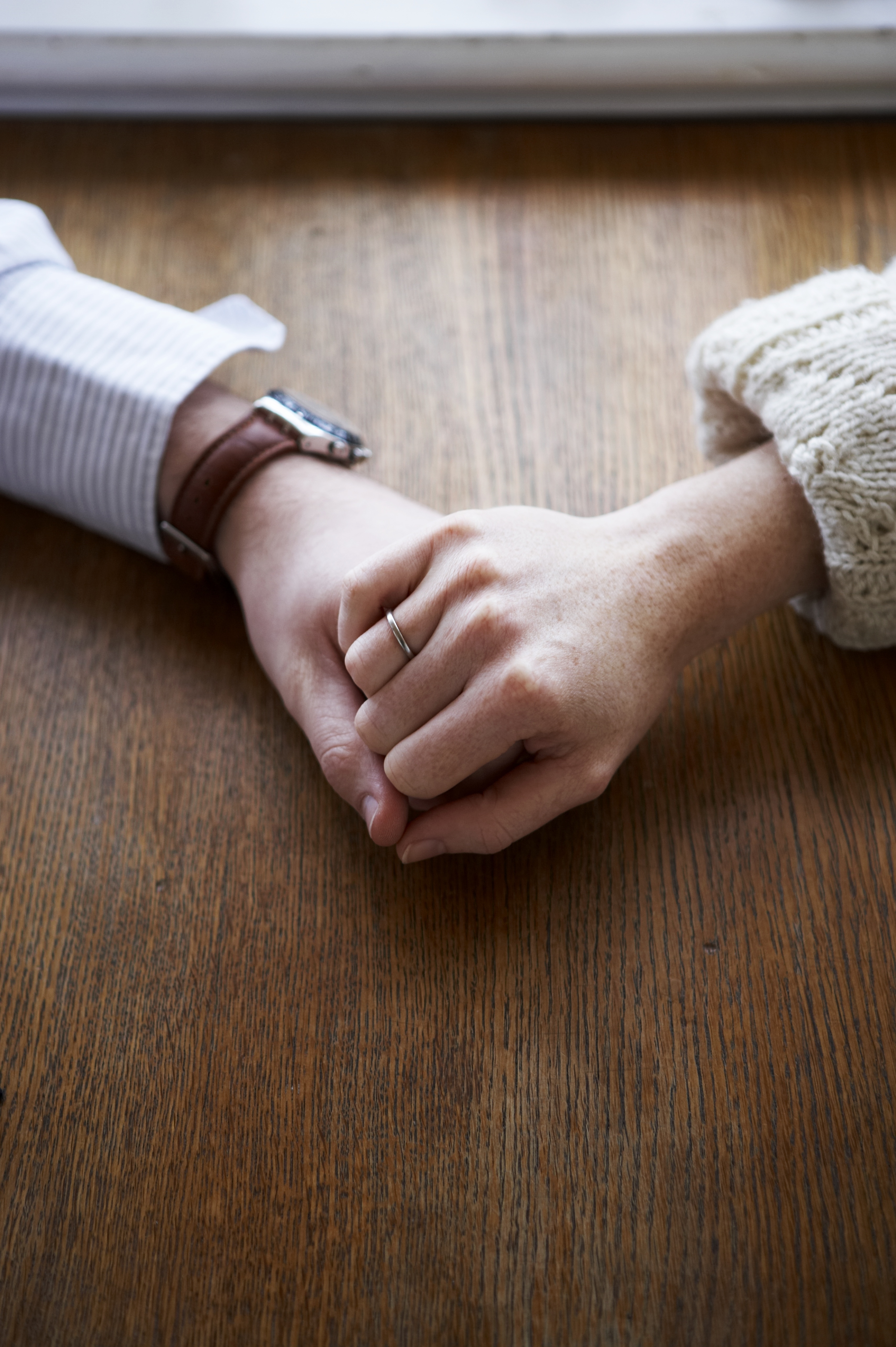couple-holding-hands-table