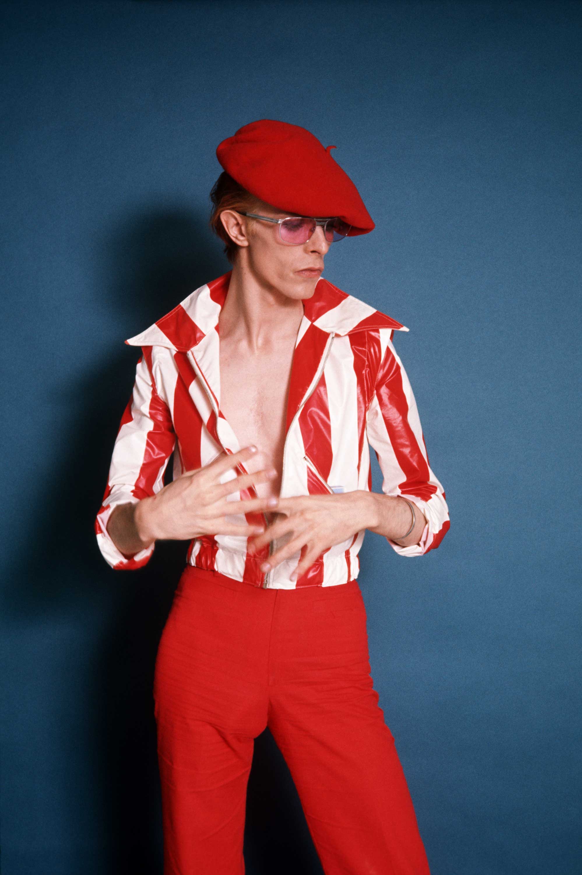 Steve Schapiro: In this previously unpublished photo, David took me by surprise when he came out in the red and white striped outfit during  the 1974 photo shoot. It was different from what we expected  he would be wearing. Los Angeles, 1974.