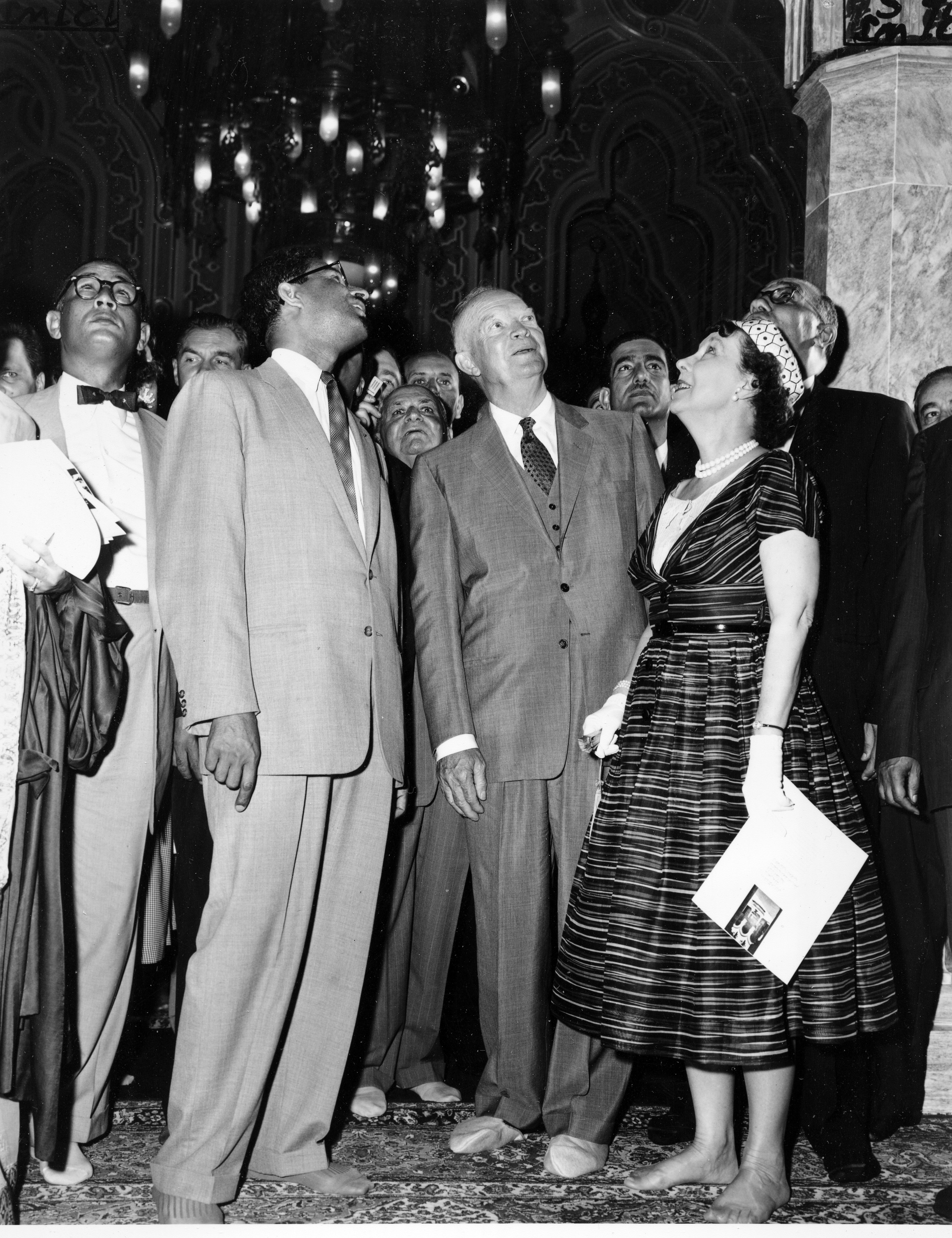 First lady Mamie Doud Eisenhower and U.S. President Dwight D. Eisenhower stand shoeless as they admire the architectural details pointed out by Sheikh Abdullah Al-Khayyal, Saudi Arabian ambassador, at the dedication ceremony of the Islamic Center and Mosque, in Washington, on June 28, 1957. (AP)