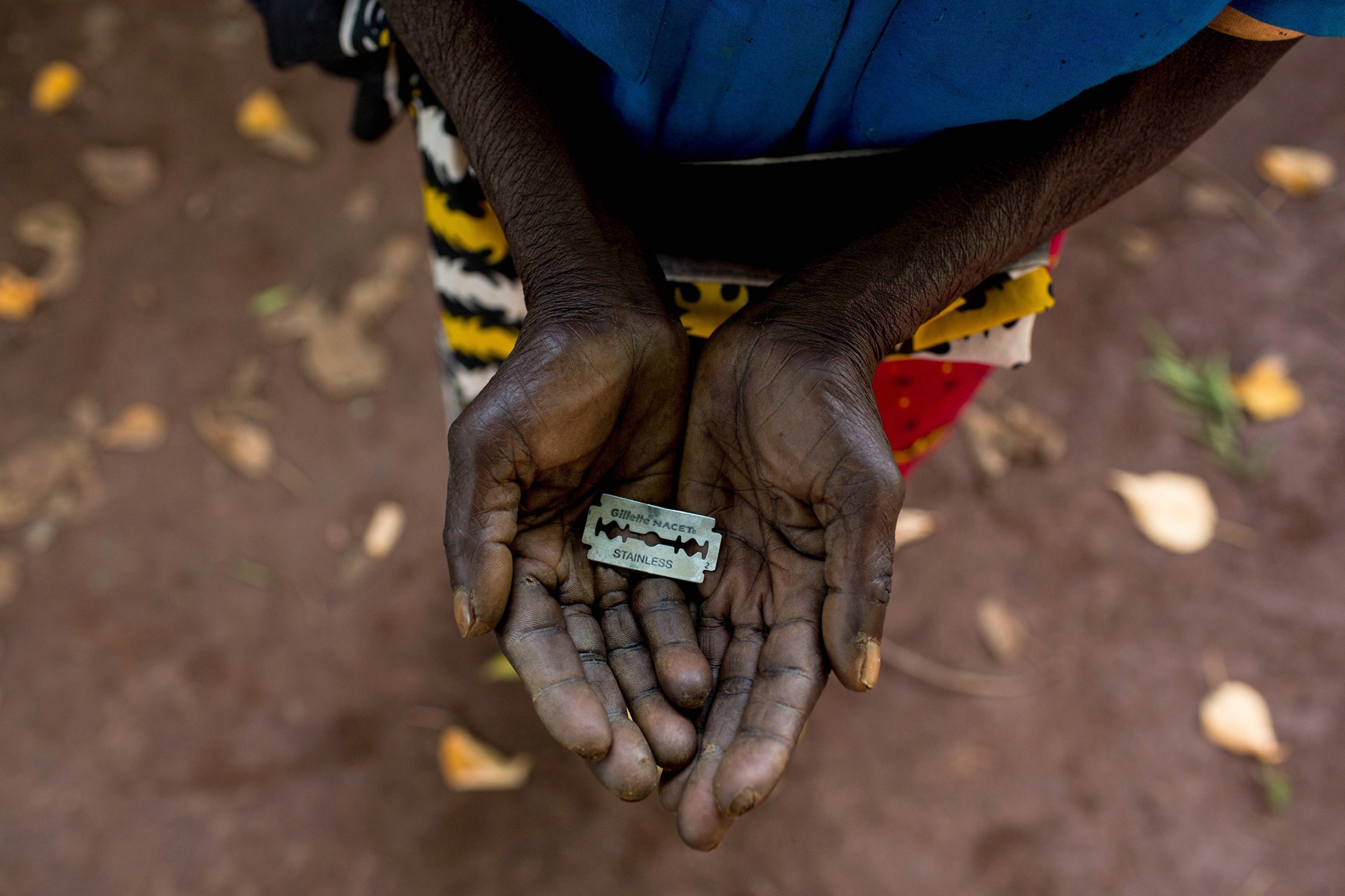A woman shows the razor blade that she uses to cut girls' genitals in Mombasa, Kenya, June 25, 2015.