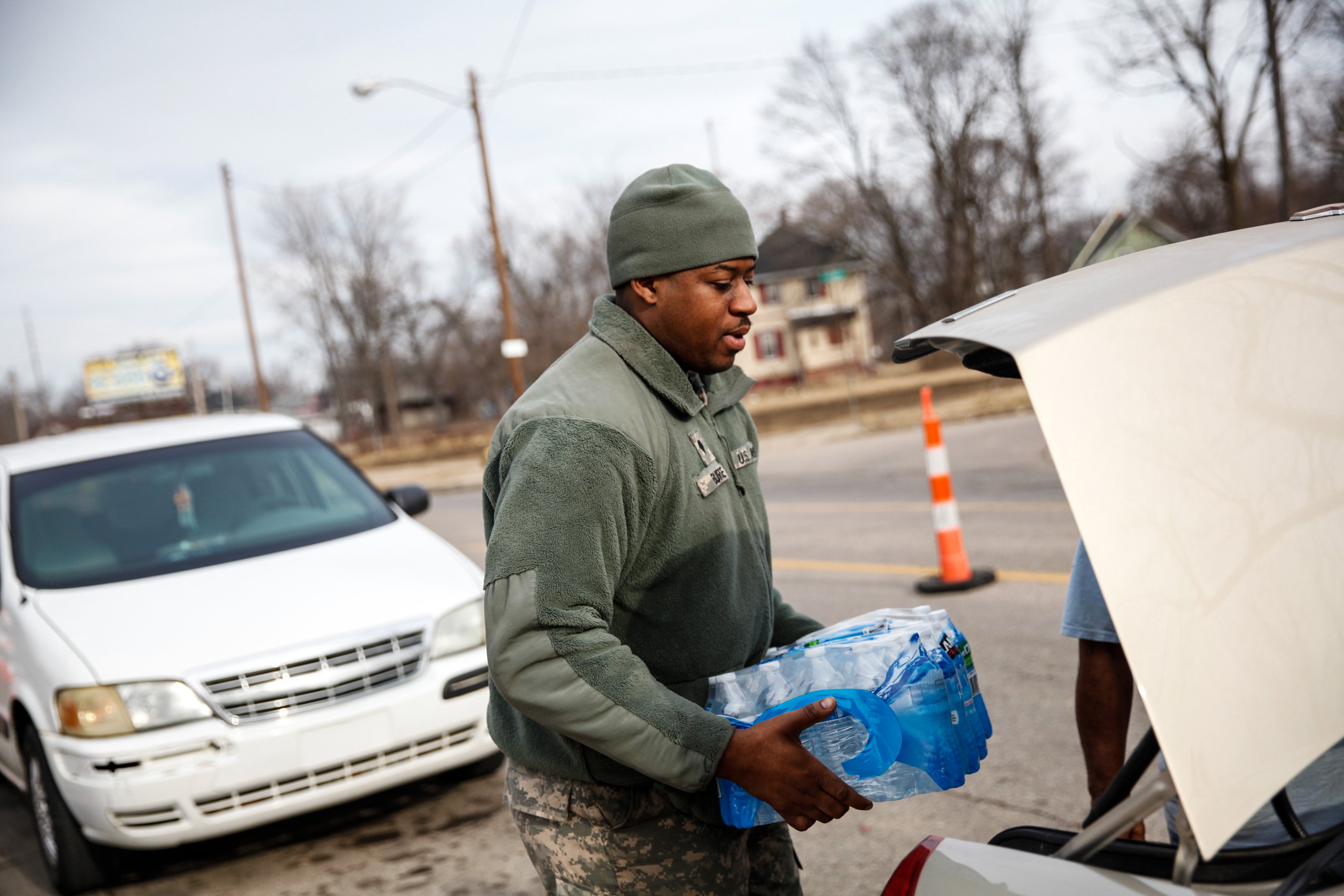 FLINT, MI - FEBRUARY 7:  Army National Guard Spc. Terence Burse carries bottled water out to the car for a resident on February 7, 2016 in Flint, Michigan. Months ago the city told citizens they could use tap water if they boiled it first, but now say it must be filtered to remove lead.  (Photo by Sarah Rice/Getty Images)
