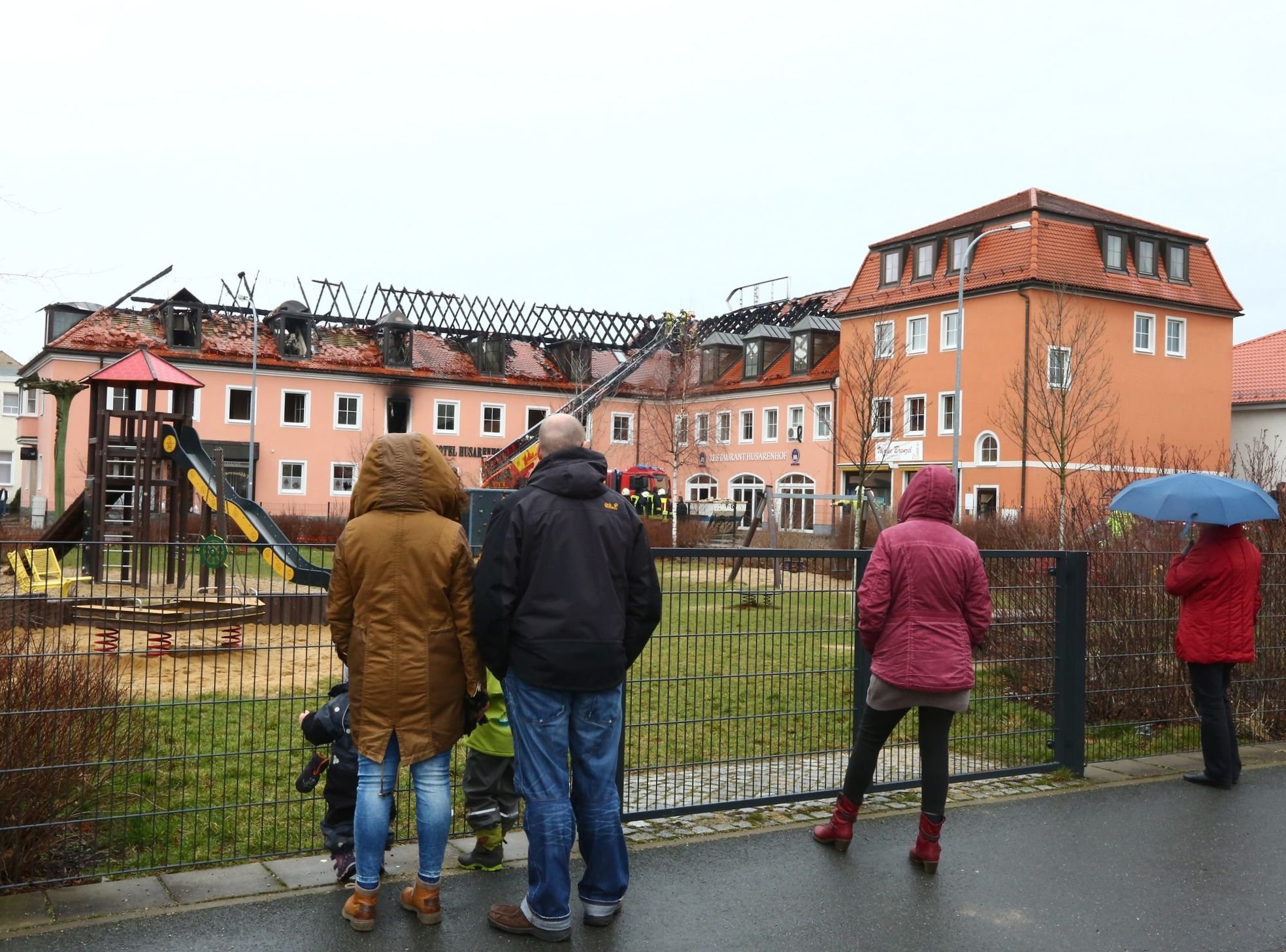 People look at the burnt-out roof of a former hotel that was under reconstruction to become a shelter for migrants in Bautzen, Germany, Feb. 21, 2016. (Christian Essler—AFP/Getty Images)