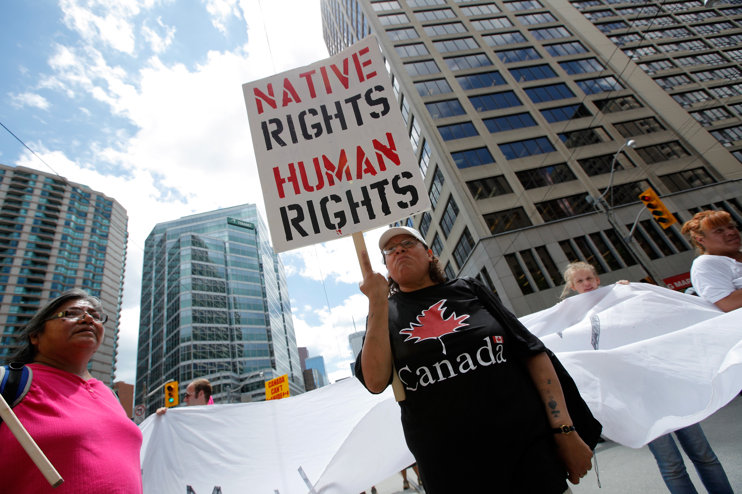 A woman holds a sign as several hundred indigenous people march through the streets of Toronto to bring attention to the plight of indigenous peoples in Canada on June 24, 2010 (Jemal Countess—Getty Images)