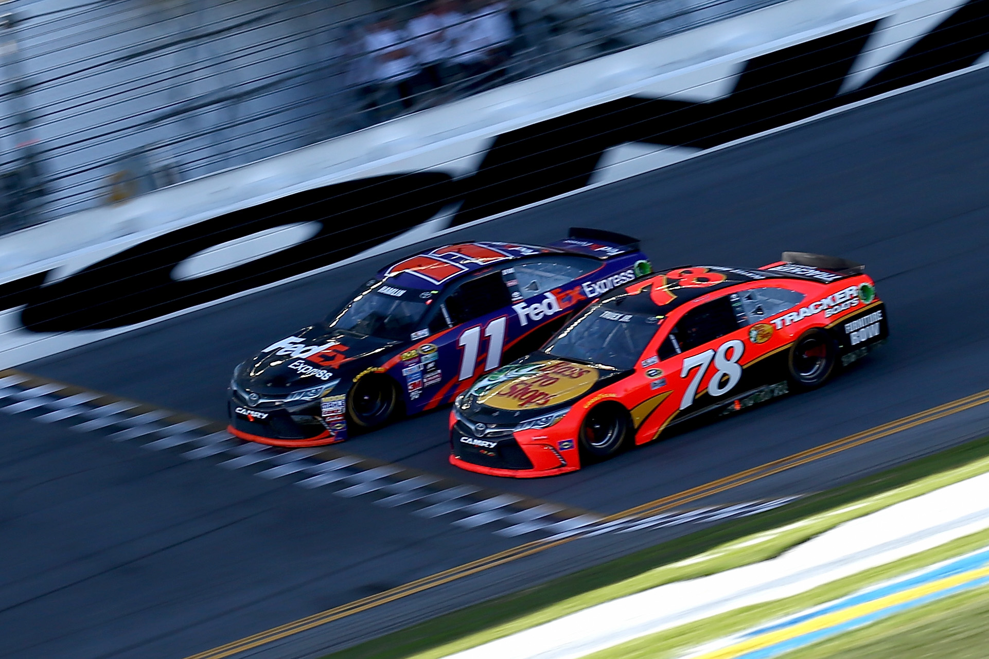 Denny Hamlin, driver of the #11 FedEx Express Toyota, takes the checkered flag ahead of Martin Truex Jr., driver of the #78 Bass Pro Shops/Tracker Boats Toyota, to win the NASCAR Sprint Cup Series Daytona 500 on Feb. 21, 2016 in Daytona Beach, Fla. (Sarah Crabill—NASCAR /Getty Images)