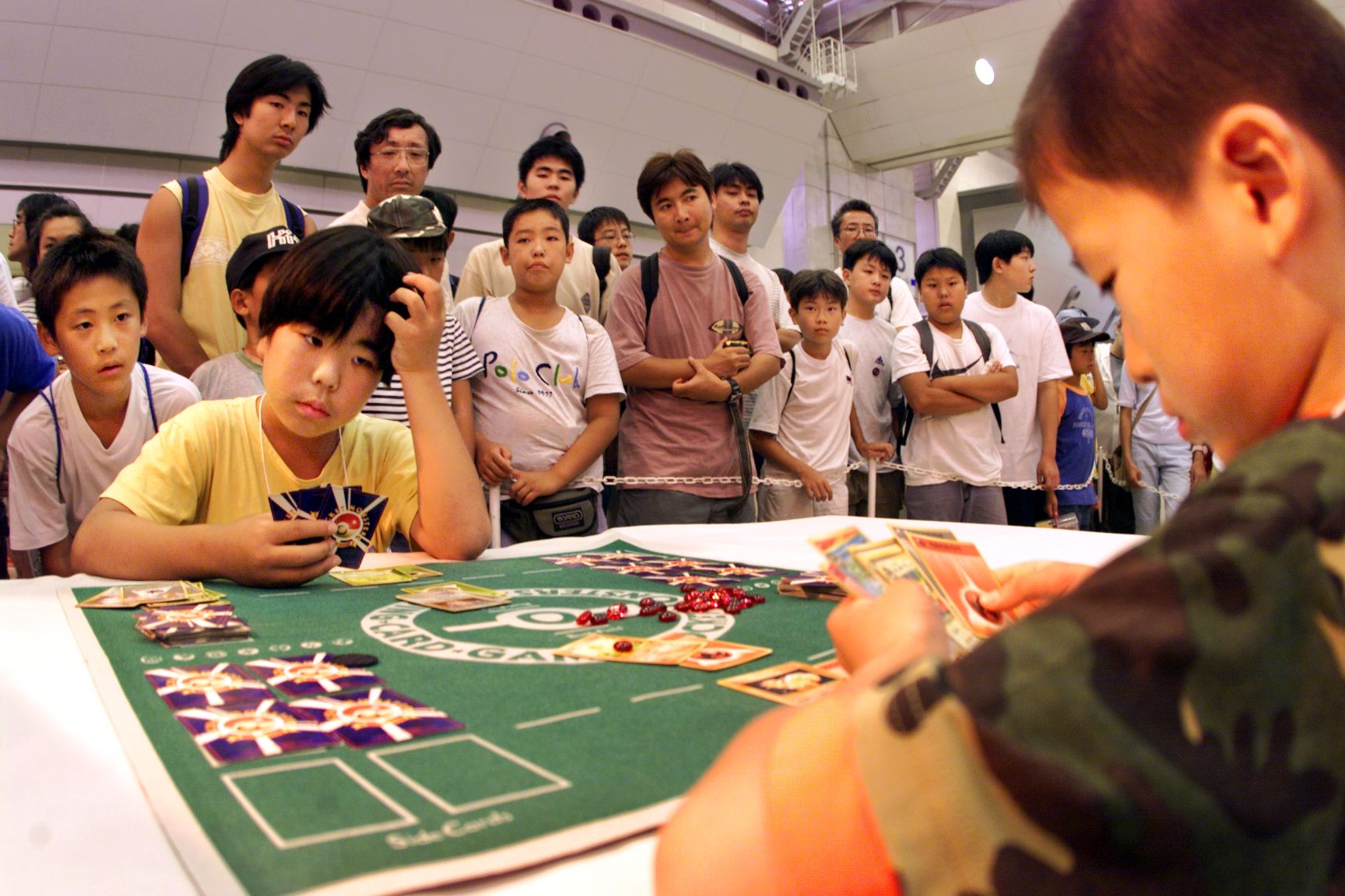 A crowd watches as Japanese boys play a close game in Tokyo 04 August 1999 as they participate in a Pokemon (Pocket Monster) card game tournament. (Yoshikazu Tsuno—AFP/Getty Images)