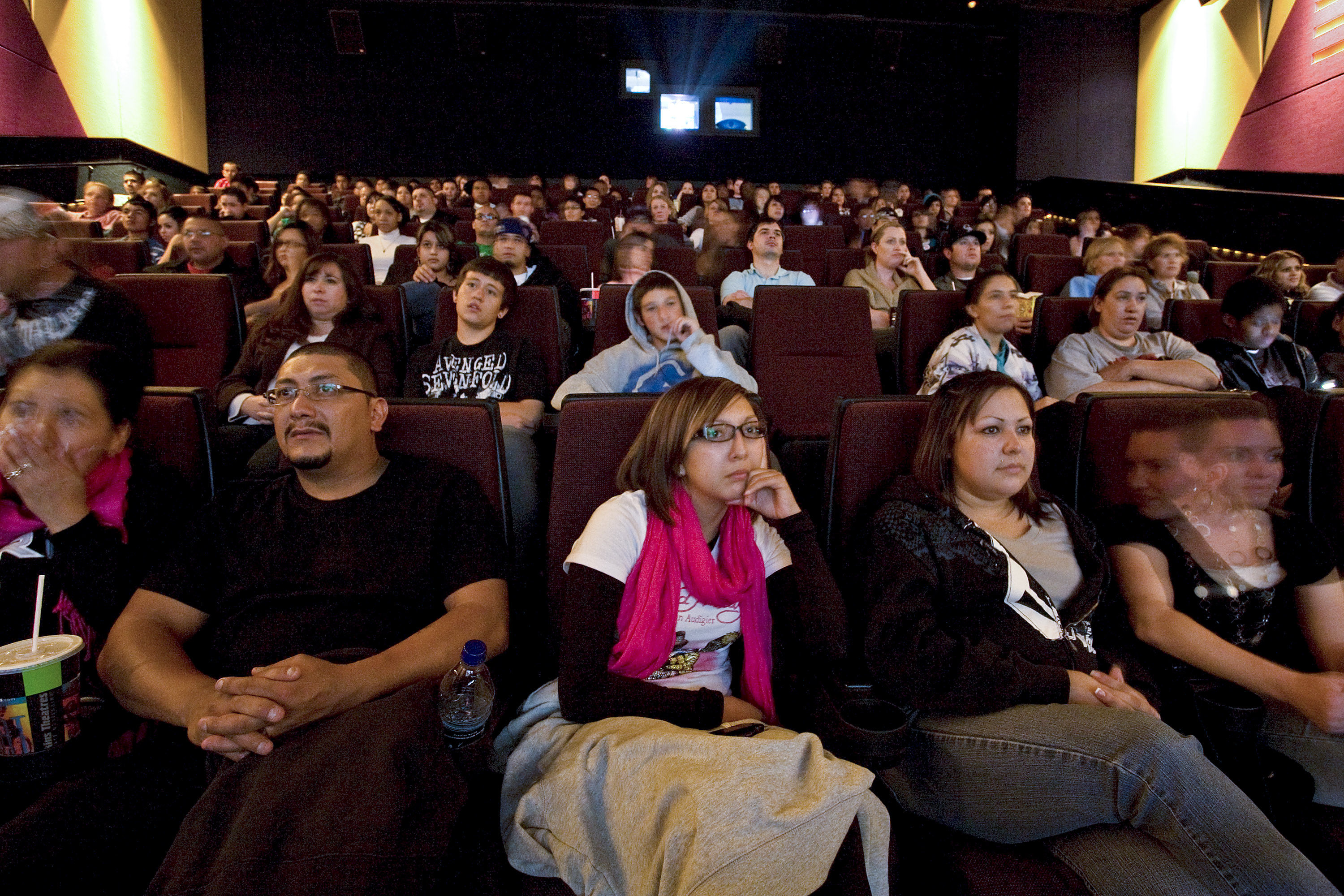 Movie-goers, from left, Michelle Vargas, Rudy Vargas, Brittany Vargas, Janelle Bonilla, and Tiffany McIntosh watch previews at a Harkins movie theater in Denver, Colorado, U.S., on Friday, Oct. 16, 2009. (Bloomberg—Bloomberg via Getty Images)