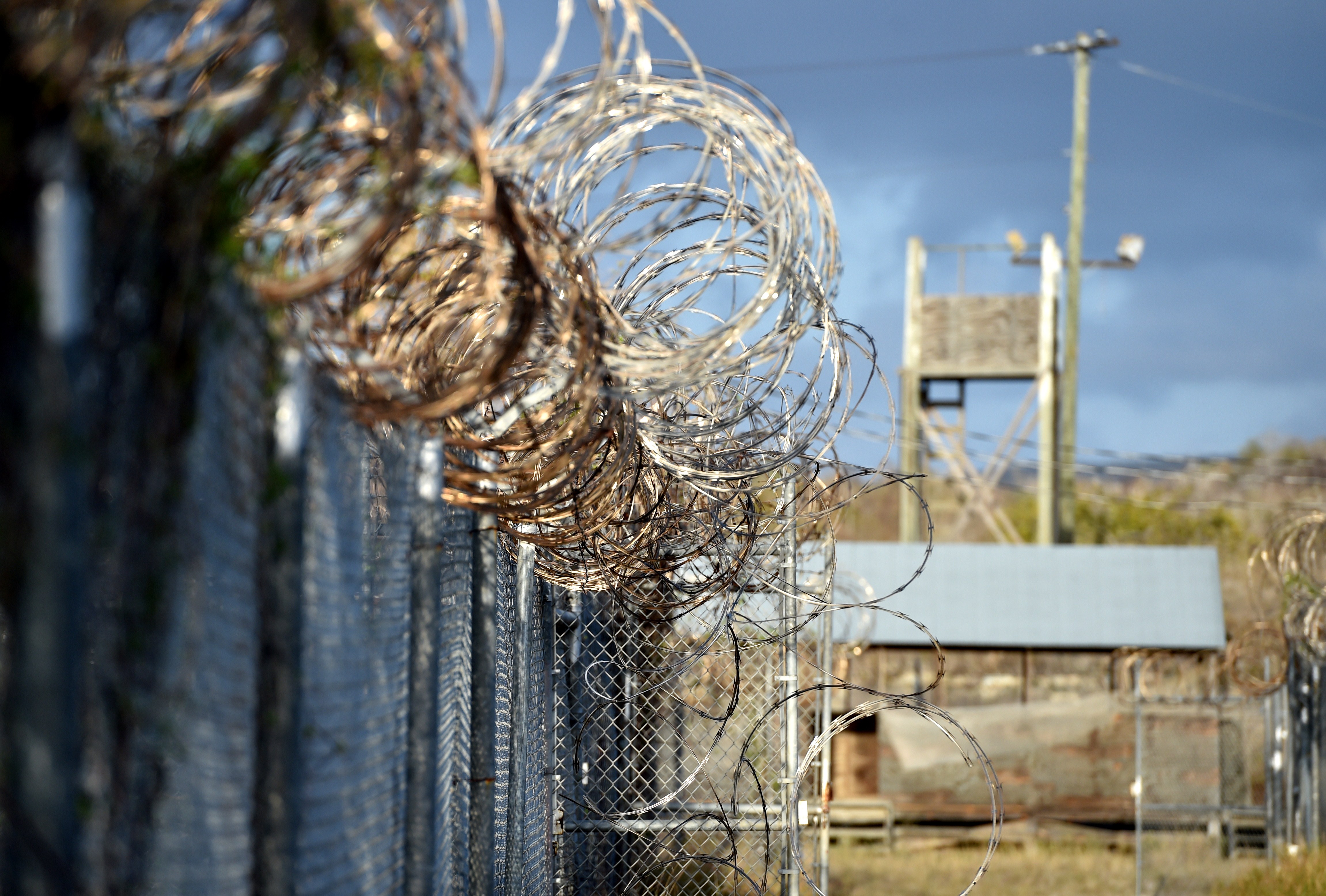 This photo made during an escorted visit and reviewed by the US military, shows the razor wire-topped fence at the abandoned "Camp X-Ray" detention facility at the US Naval Station in Guantanamo Bay, Cuba. (Mladen Antonov—AFP/Getty Images)