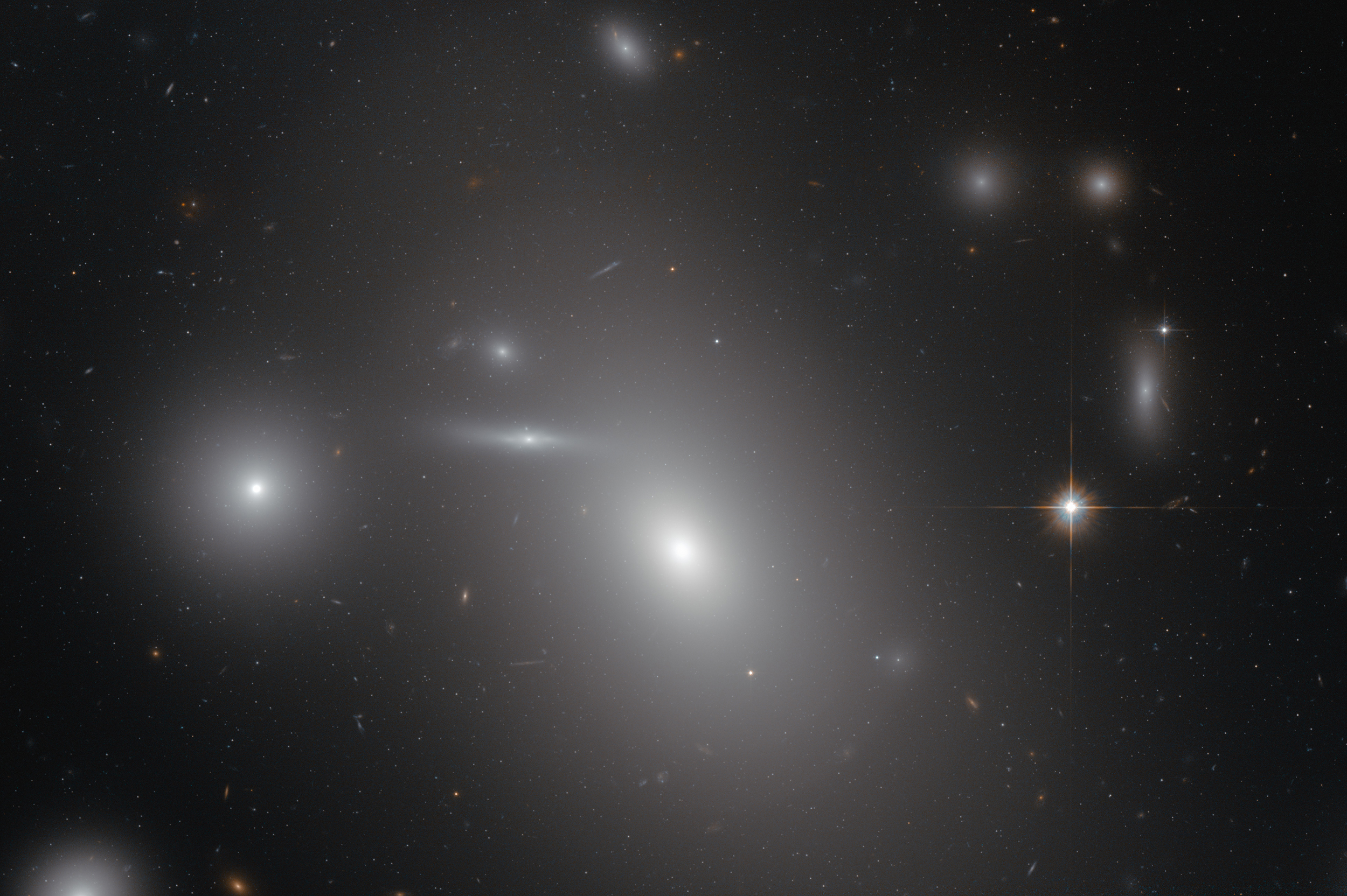 The elliptical galaxy NGC 4889 in front of hundreds of background galaxies, and deeply embedded within the Coma galaxy cluster. Hidden from human eyes, is a gigantic supermassive black hole at the centre of the galaxy. (NASA/ESA)