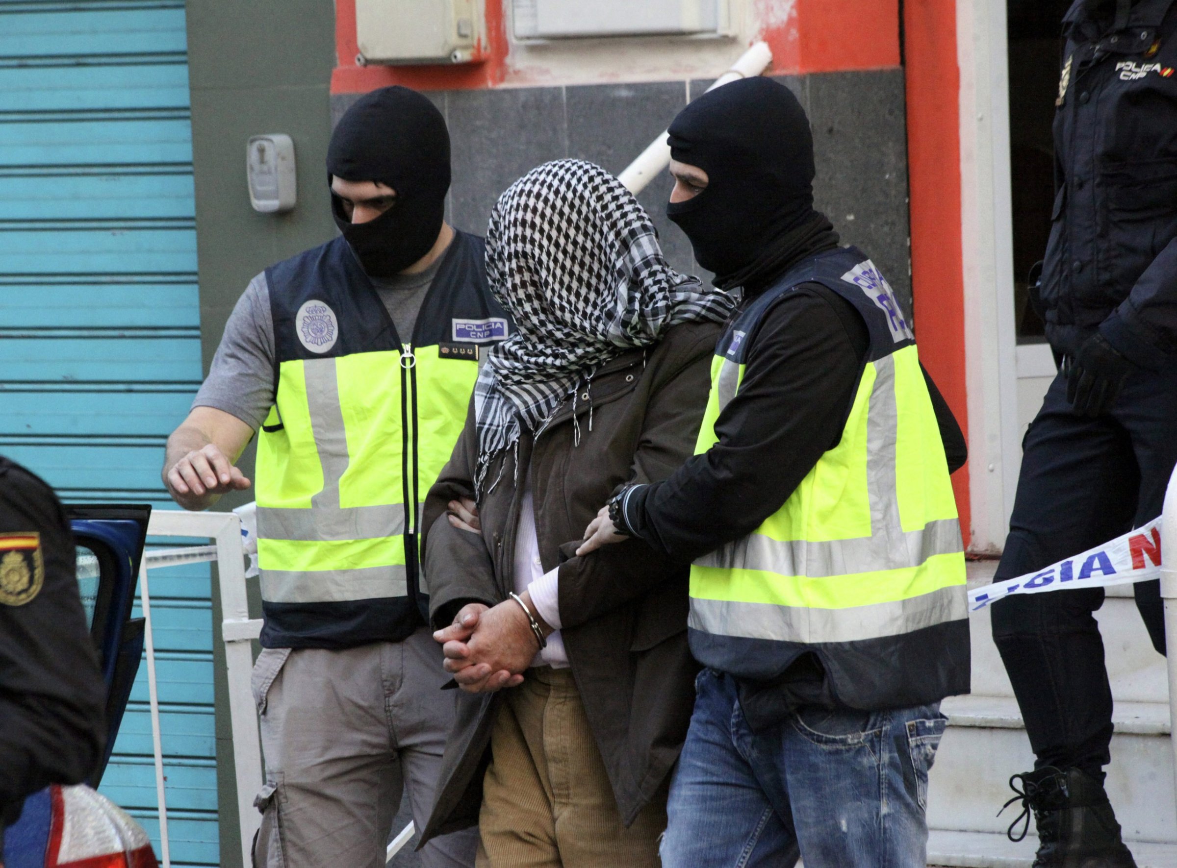 Spanish policemen escort a man who was arrested during a operation against Jihadist terrorism in Ceuta, Spanish enclave in northern Africa, on Feb. 7, 2016.