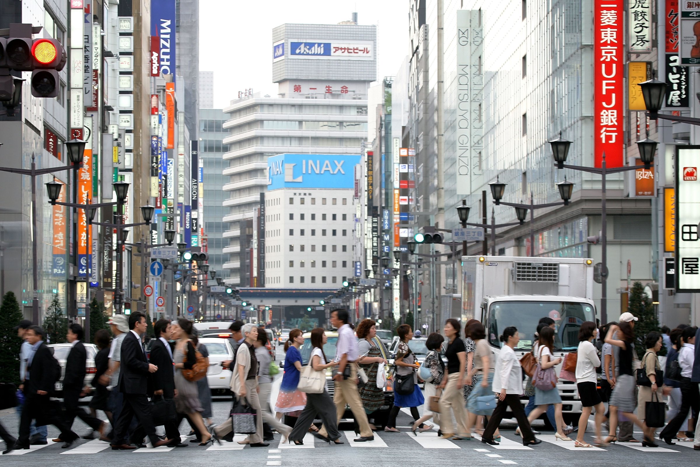 People walk across the street in the Ginza district on July 10, 2009 in Tokyo, Japan.