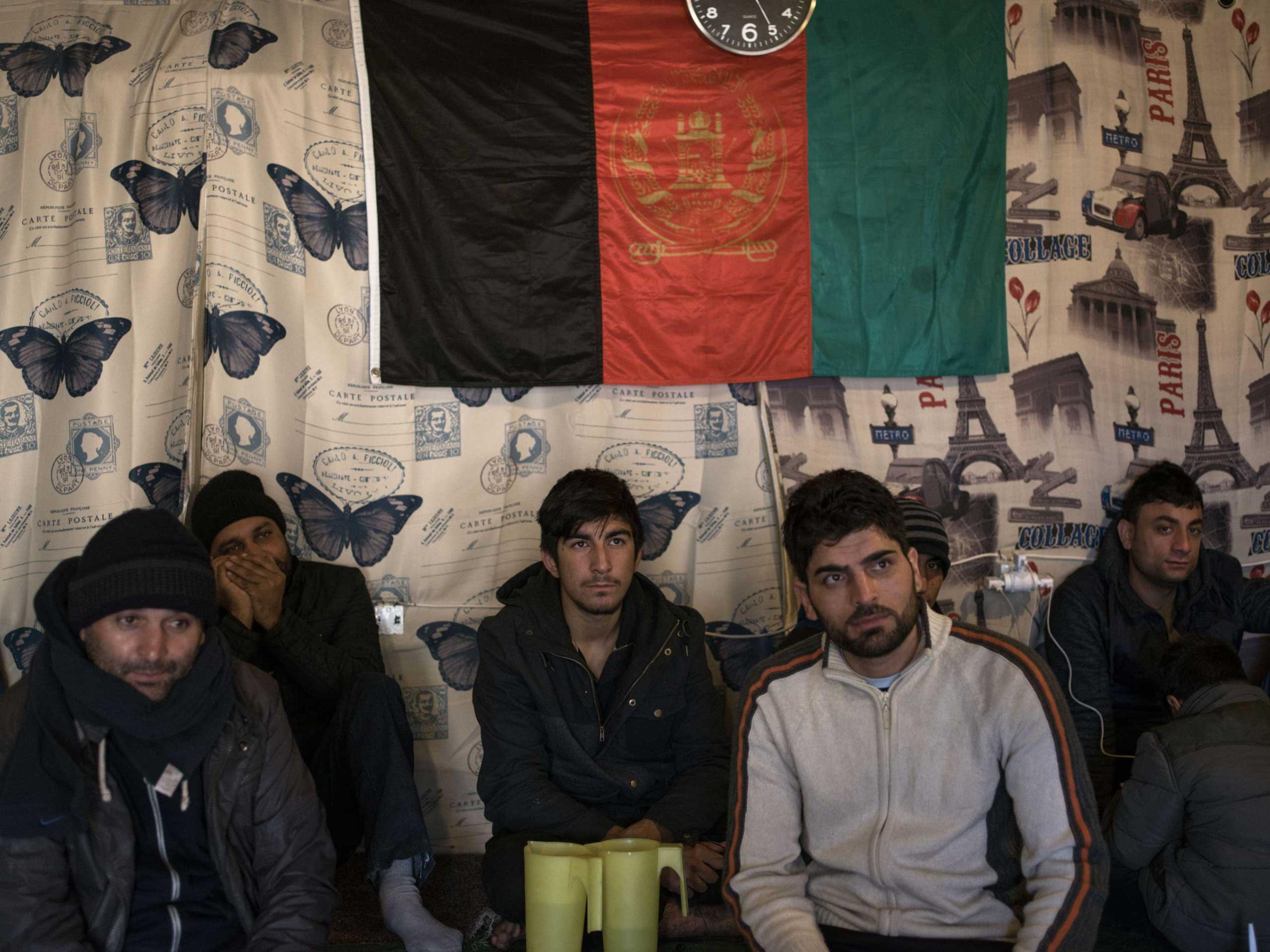 Men sit at an Afghan restaurant in the "jungle", Calais, France, Nov. 25, 2015.