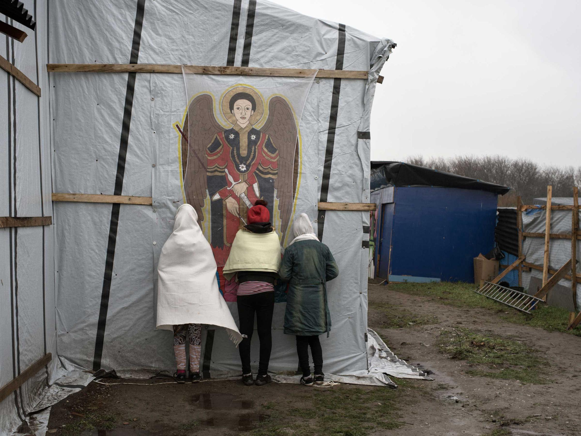Orthodox Christians pray outside the makeshift church known as St. Michael's Calais  for the Ethiopian and Eritrean community in the "jungle" of Calais, France, Nov. 24, 2015.