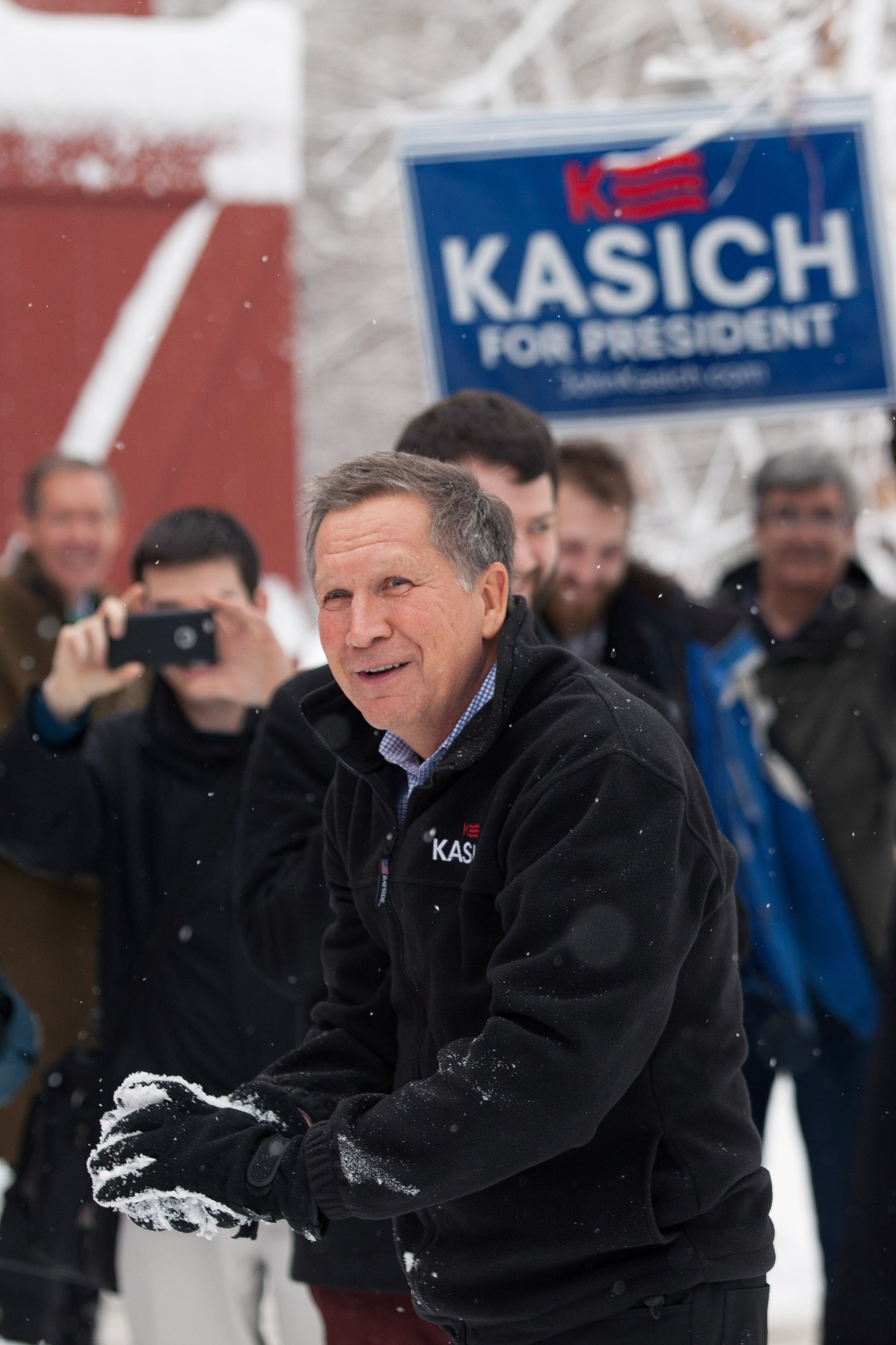 HOLLIS, NH - FEBRUARY 05: Ohio Governor and Republican presidential candidate John Kasich smiles during a snowball fight with his staff following a town hall style meeting on February 5, 2016 in Hollis, New Hampshire. Democratic and Republican Presidential candidates are stumping for votes throughout New Hampshire leading up to the Presidential Primary on February 9th.  (Photo by Matthew Cavanaugh/Getty Images)