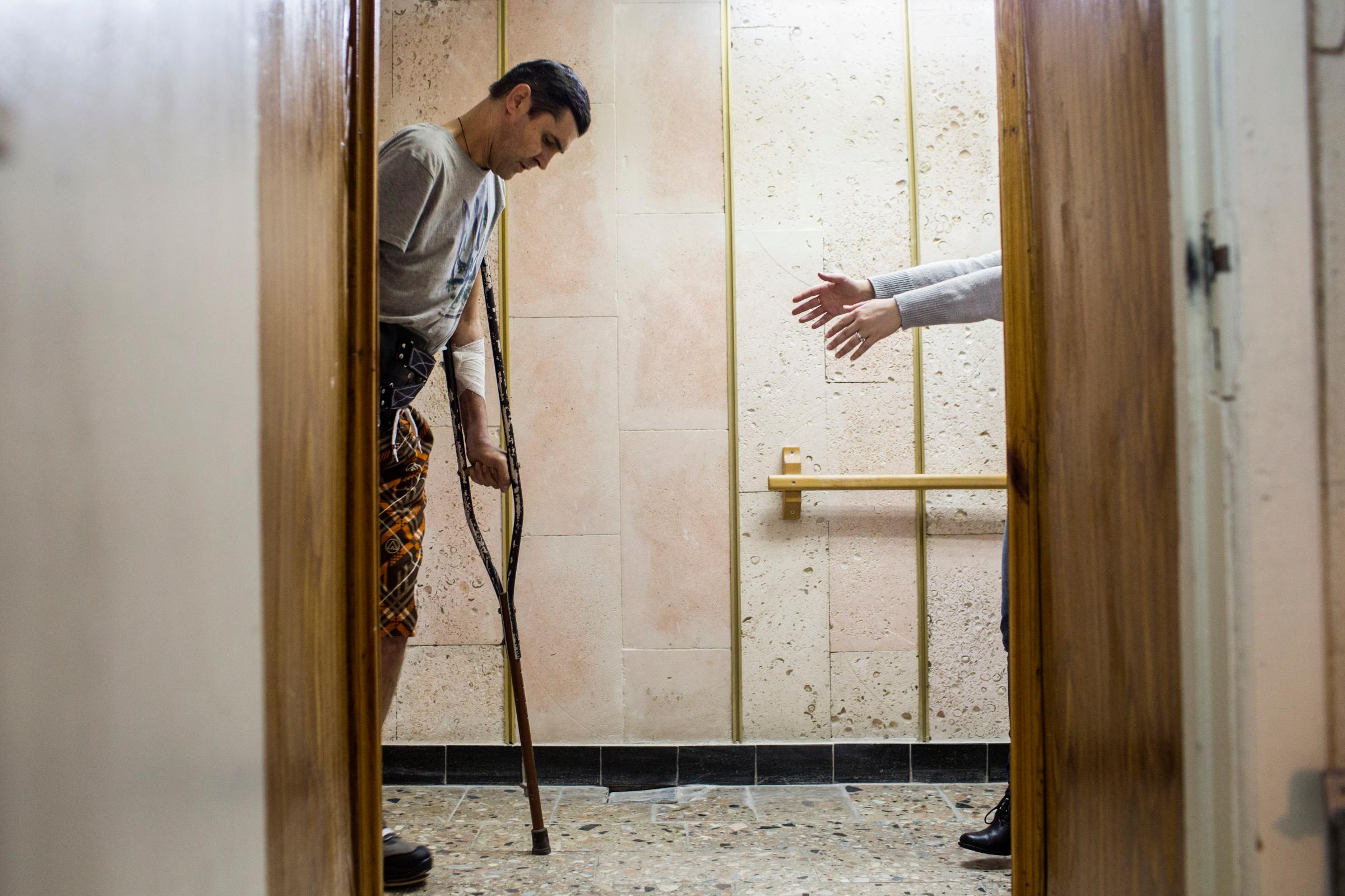 Viacheslav Buinovsky, 41, walks toward a close friend as he takes some of his first steps using a prosthetic leg at Ortotech Service, a prosthetics workshop in Kiev, Ukraine, Feb. 10, 2015. Buinovsky worked as a mechanic in Sumy Oblast prior to the Euromaidan revolution, in which he took an active role. He joined the Aidar Battalion, a volunteer unit, after the revolution and was severely wounded near Luhansk in September 2014. His right hand and right leg were amputated. "I would like to return to fight, but I do not have the ability," he said. "What I can do to contribute from here, I will do. Everyone who was there would like to return back ... but not everyone can."