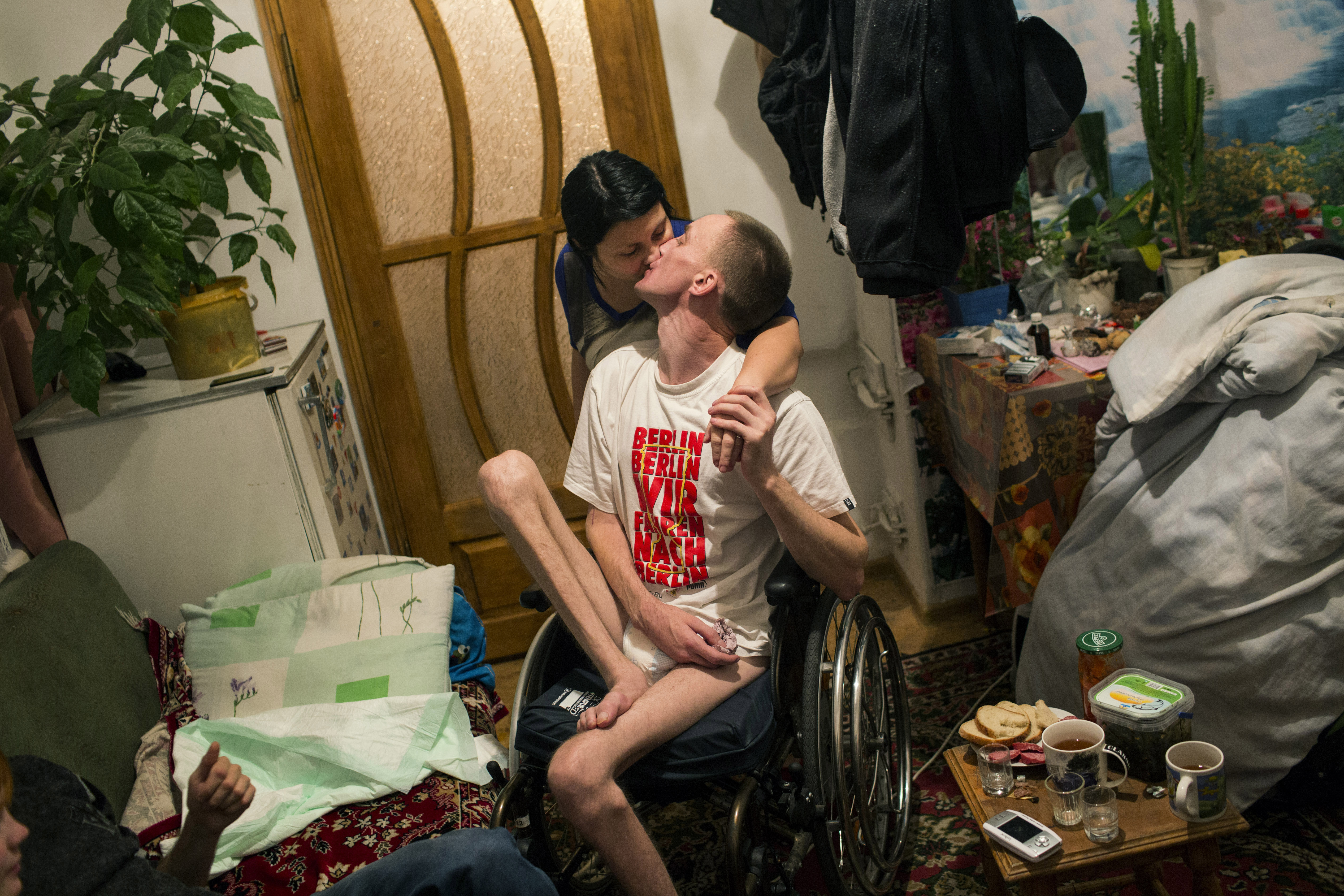 Honcharovsky kisses his wife, Oksana Khivchuk, in their home in Teofipol, Ukraine, Nov. 17, 2014.  Life for us is very difficult at the moment,  said Khivchuk.  We hoped that he would slowly begin to walk again, but as you see, there have been no changes.