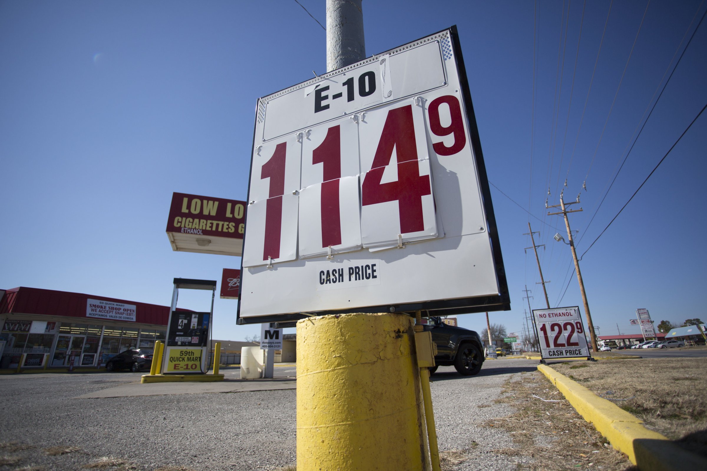 Signs in front of a gas station reflect lower gas prices in Oklahoma City on Feb. 12, 2016.