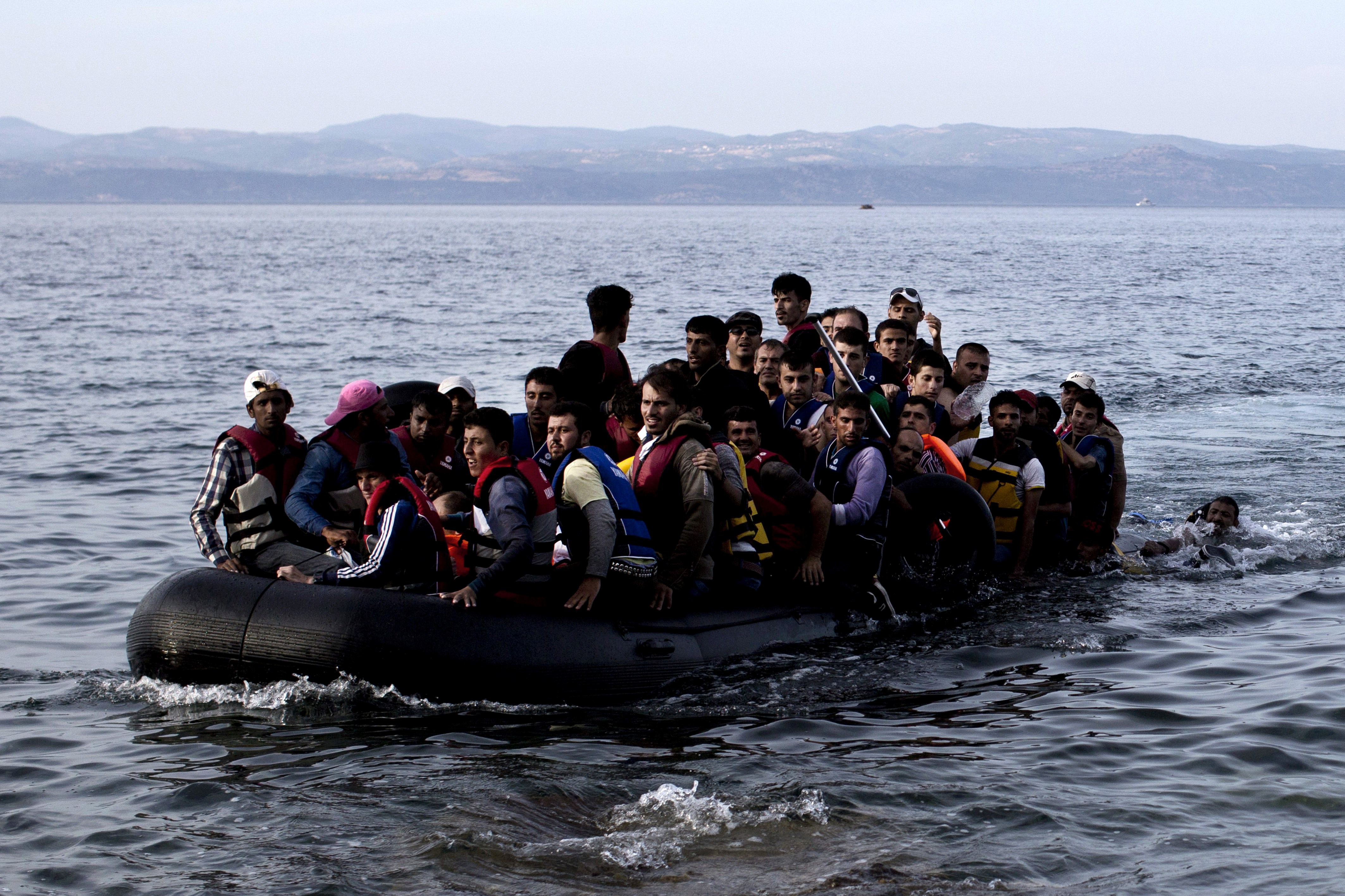 Refugees and migrants arrive on the shores of the Greek island of Lesbos after crossing the Aegean Sea from Turkey on an inflatable boat, Sept. 9, 2015. (Angelos Tzortzinis—AFP/Getty Images)