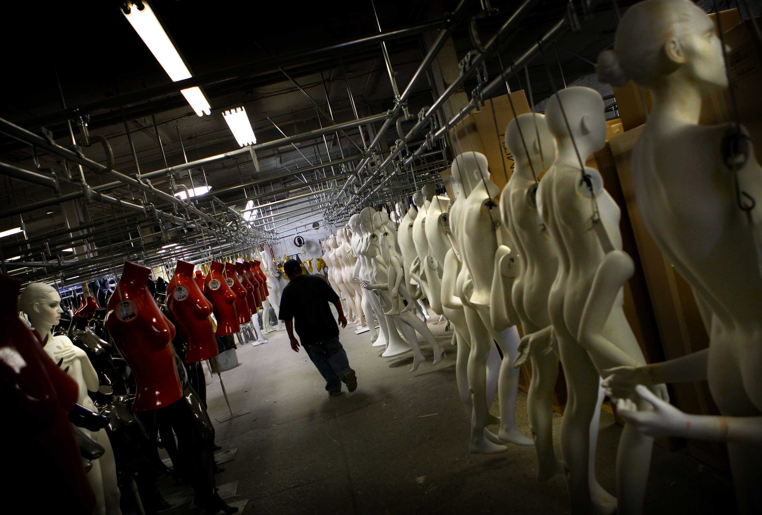 A Goldsmith employee walks next to a line of mannequins at the Goldsmith factory in New York.
