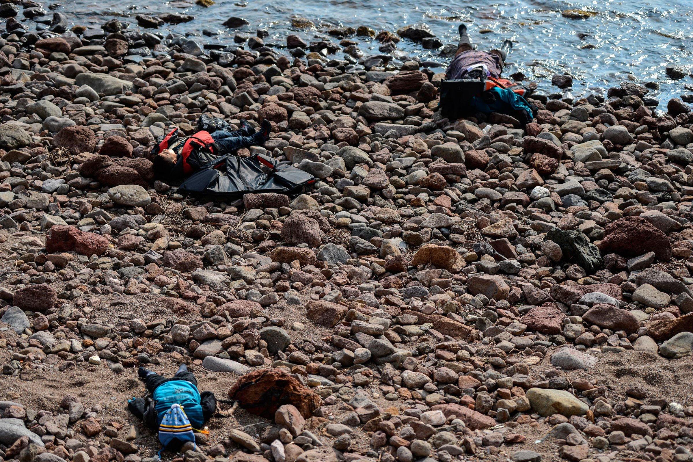 Three bodies are seen washed up on a beach after at least 37 migrants and refugees were killed when their boat sank in the Aegean while trying to cross to Greece. Canakkale, Turkey, Jan. 30, 2016.