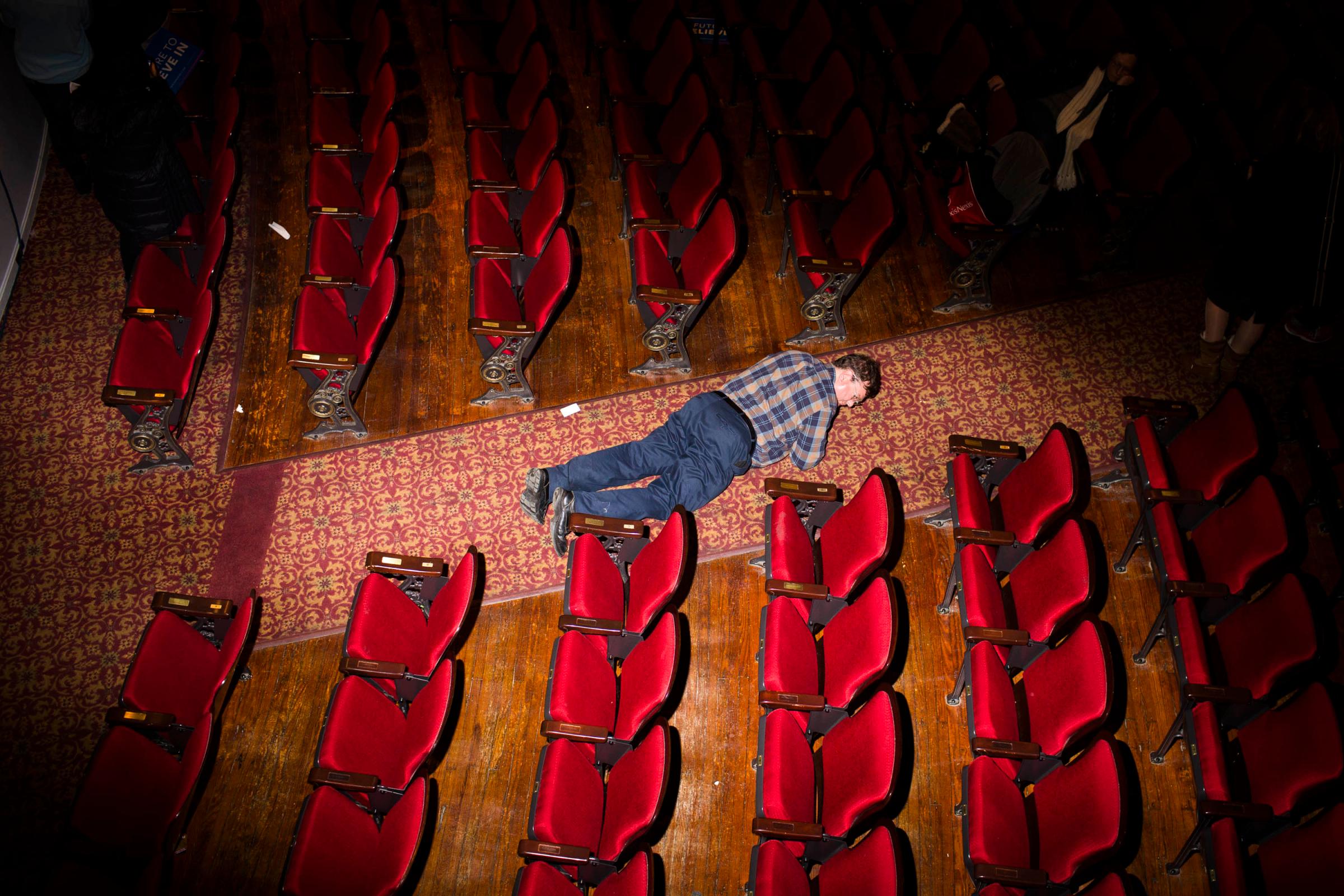 A man looks for something he dropped at the Palace Theater, where Democratic presidential candidate, Vermont Sen. Bernie Sanders held a campaign event on Feb. 8, 2016, in Manchester, N.H.