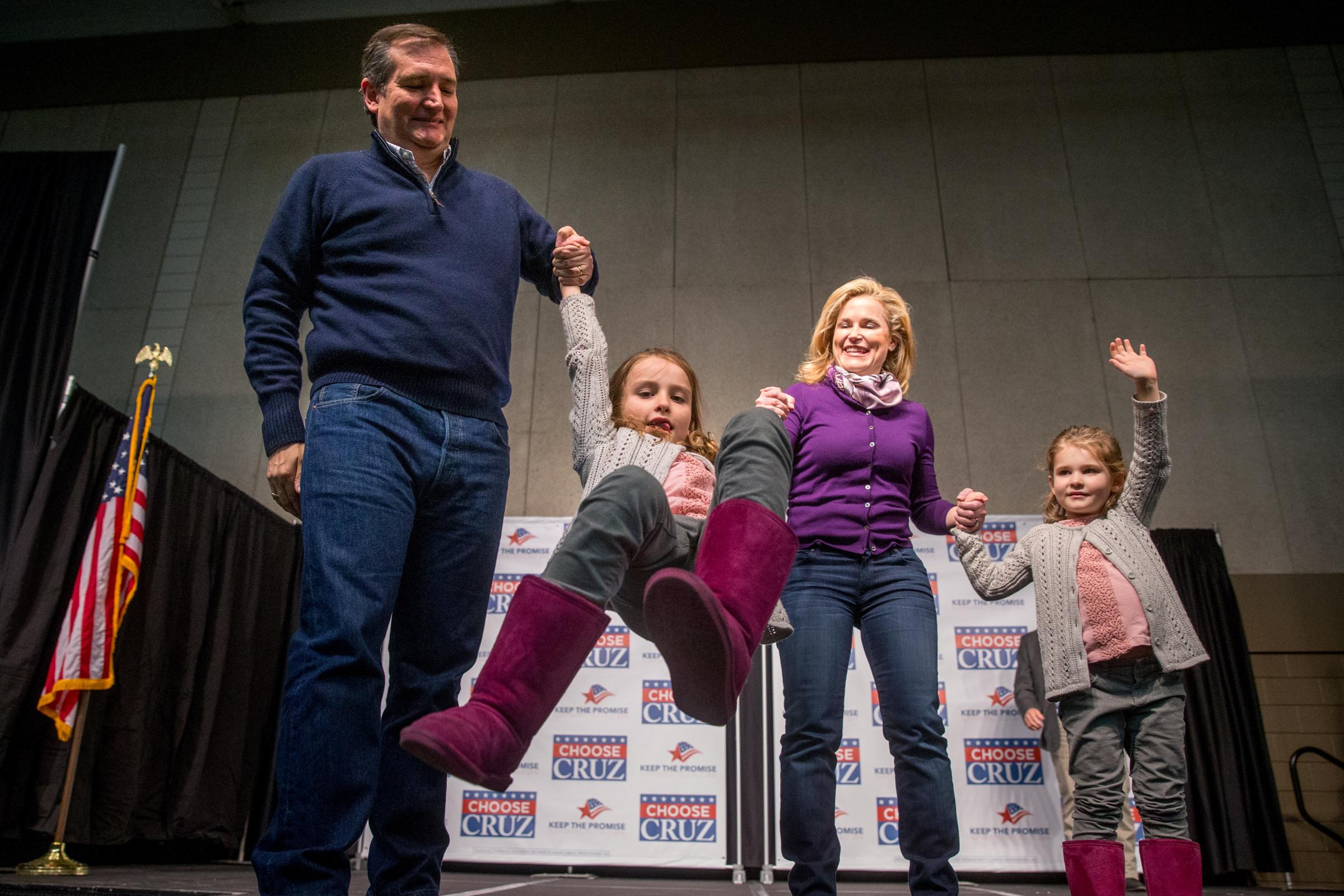 Republican presidential candidate ,Texas Sen. Ted Cruz and his wife Heidi swing their daughter Caroline, 7, as their daughter Catherine, 4, waves at a rally in Waterloo, Iowa, on Jan. 23, 2016