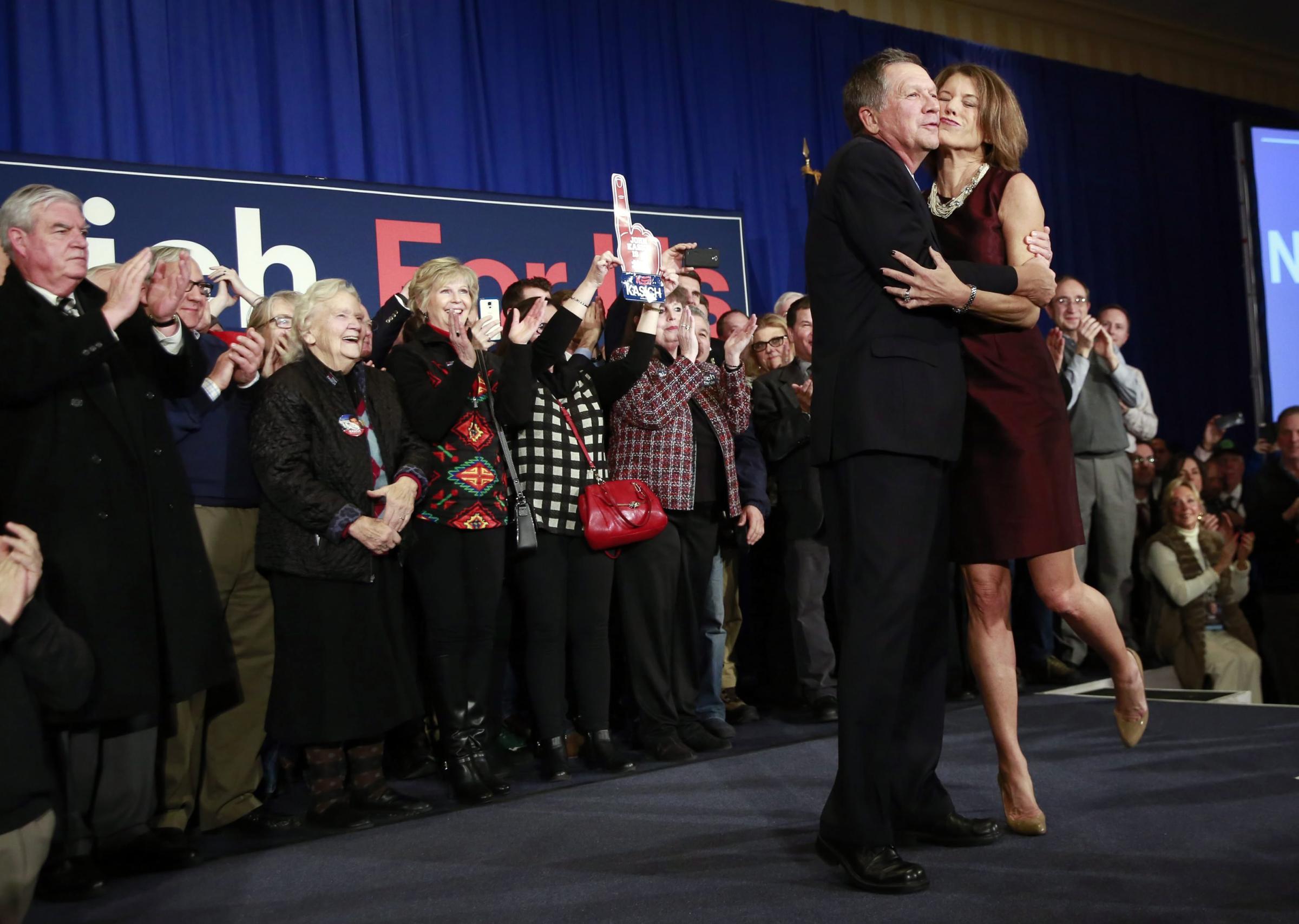 Republican presidential candidate, Ohio Gov. John Kasich is kissed by his wife Karen Waldbillig in Concord, N.H. on Feb. 9, 2016.