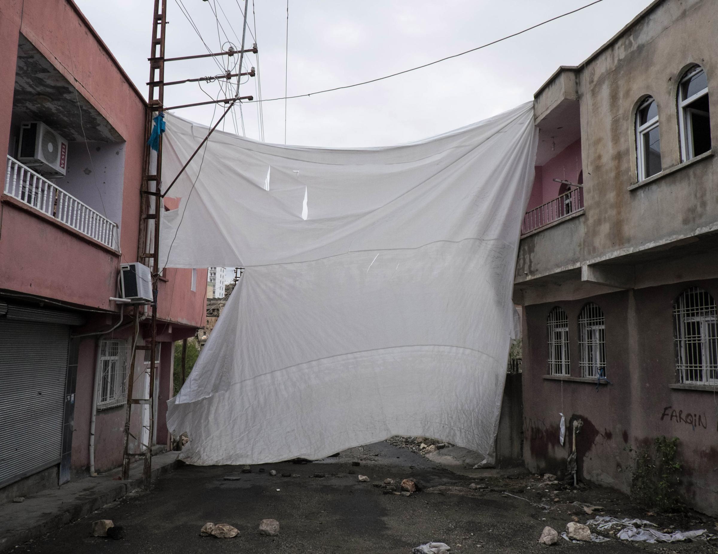 SILVAN, TURKEY - OCTOBER 27, 2015: A veil covers an entrance in the Tekel neighborhood. Since July the town of Silvan has been subjected to several curfews and teather of heavy clashes between Turkish military forces and Kurdish youh militia. A number of neighborhoods declared autonomy and built self-rule, with groups of young Kurds under the acronyms of HPG (People Defense Union) and YDGH (Patriotic Revolutionary Youth Movement) who have taken up arms and raise barricades to prevent the advances of the Turkish forces.