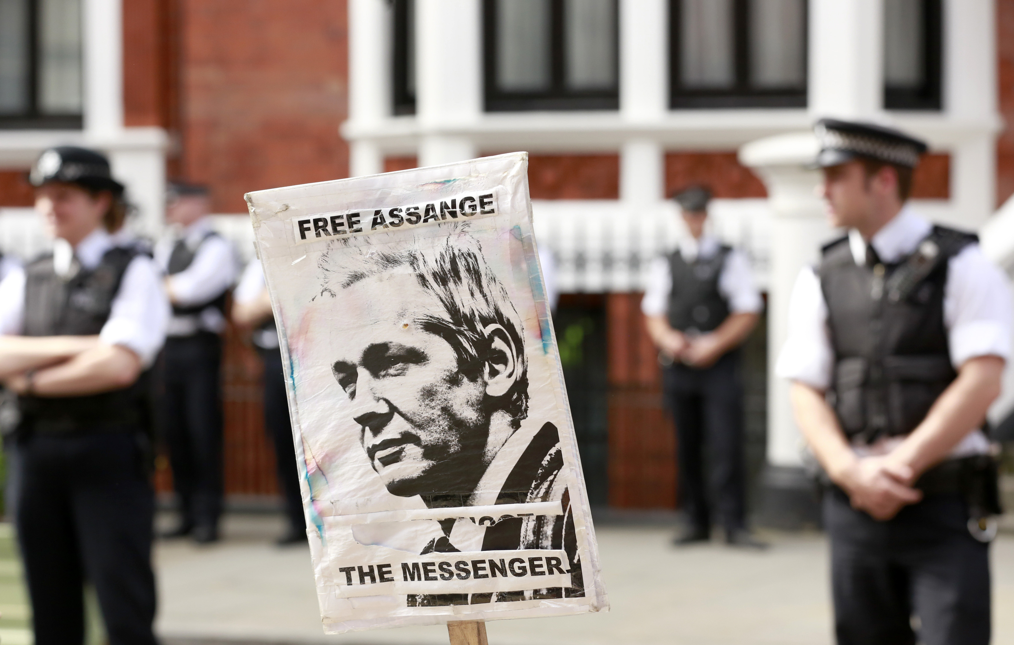 Police and protesters wait for Wikileaks founder Julian Assange to speak to the media outside the Ecuador embassy in west London