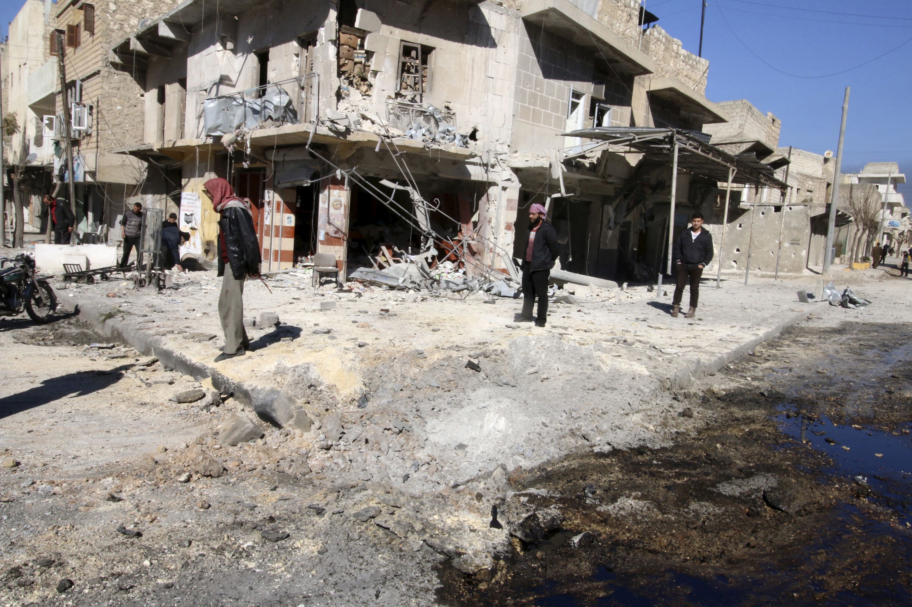Residents inspect damage near a hole in the ground after airstrikes by pro-Syrian government forces in the rebel held Al-Shaar neighborhood of Aleppo, Syria February 4, 2016. (Abdalrhman Ismail—Reuters)