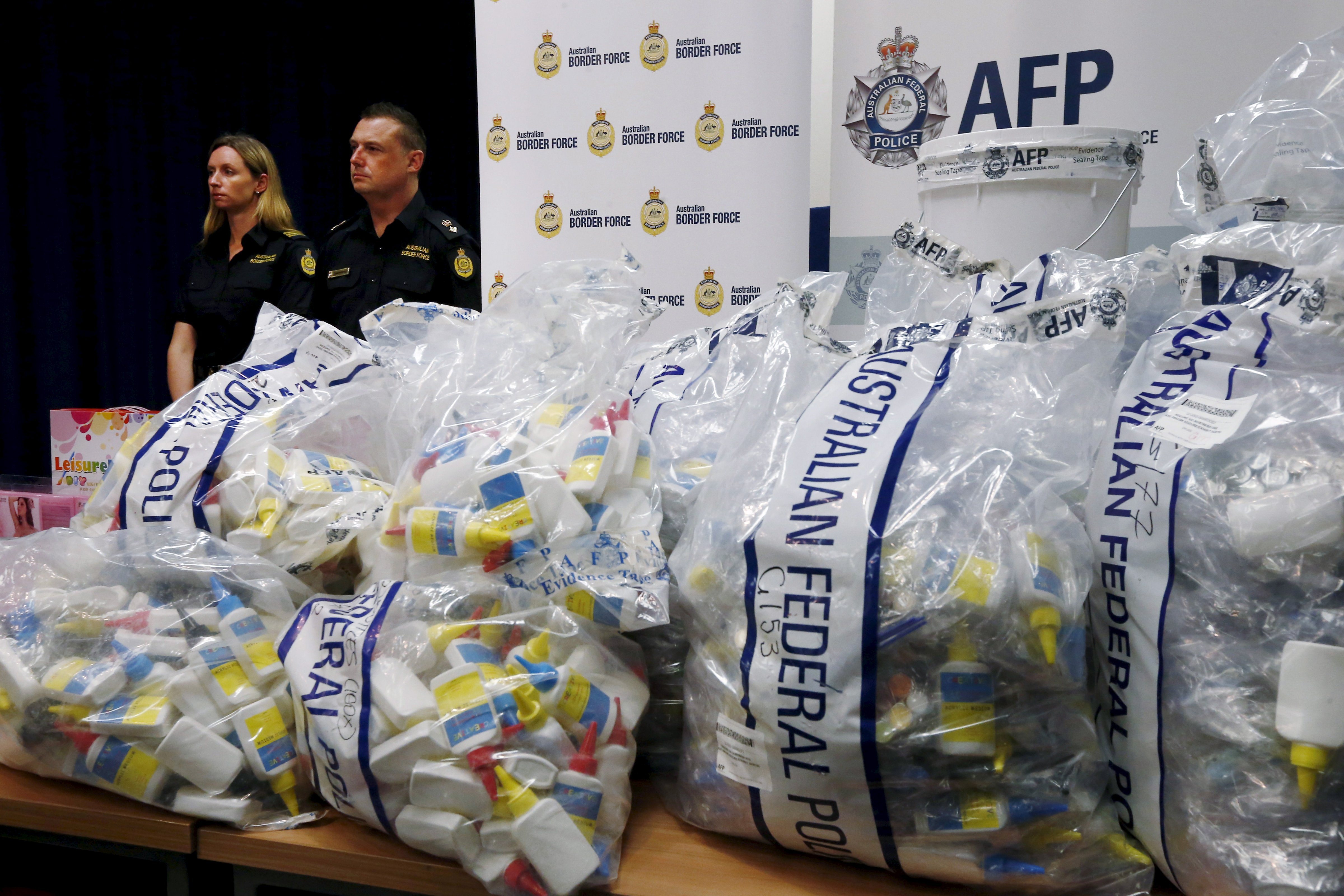 A quantity of liquid methamphetamine disguised in various packaging is put on display by Australian Border Force officers at the Australian Federal Police headquarters in Sydney
