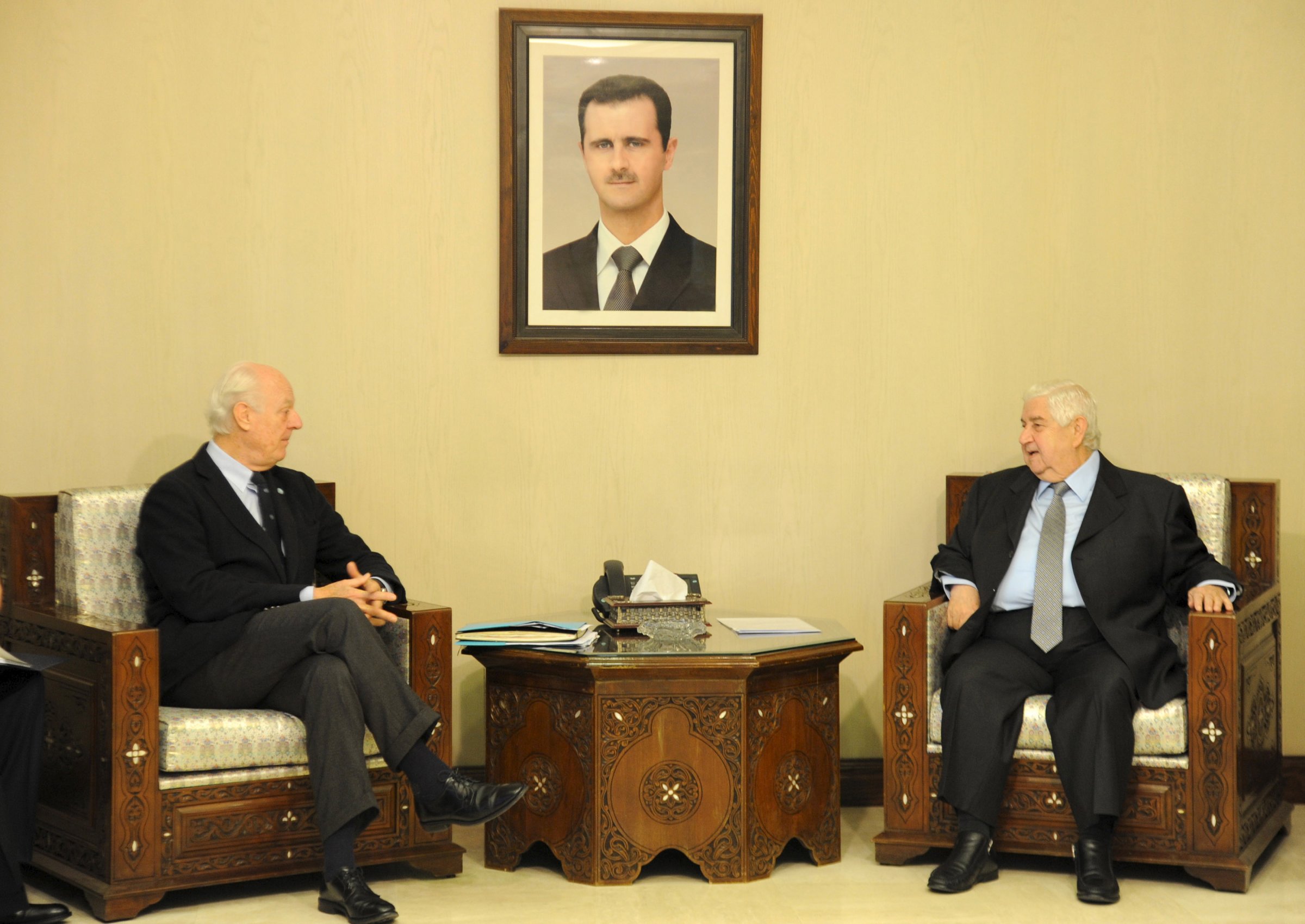 SANA handout photo shows Syria's Foreign Minister Walid al-Moualem (R) talking  with U.N. Special Envoy for Syria Staffan de Mistura (L) in Damascus