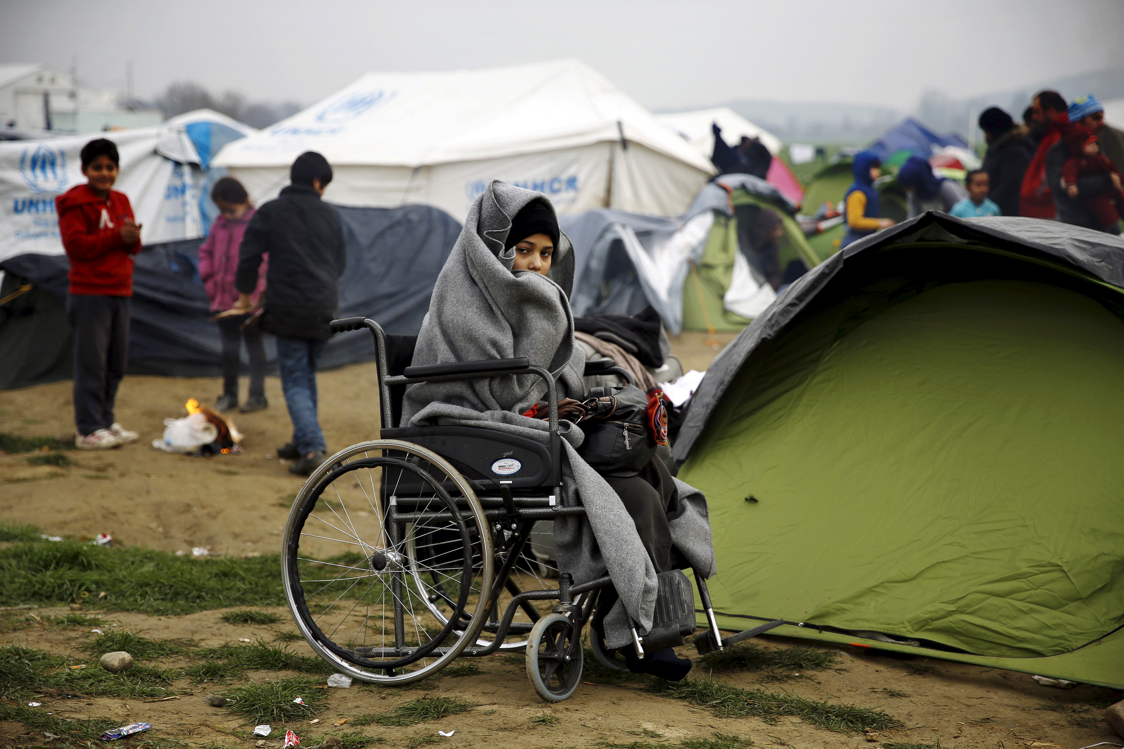 A temporarily stranded Syrian refugee is seen on a wheelchair on a field at a makeshift camp next to the Greek-Macedonian border, near the Greek village of Idomeni