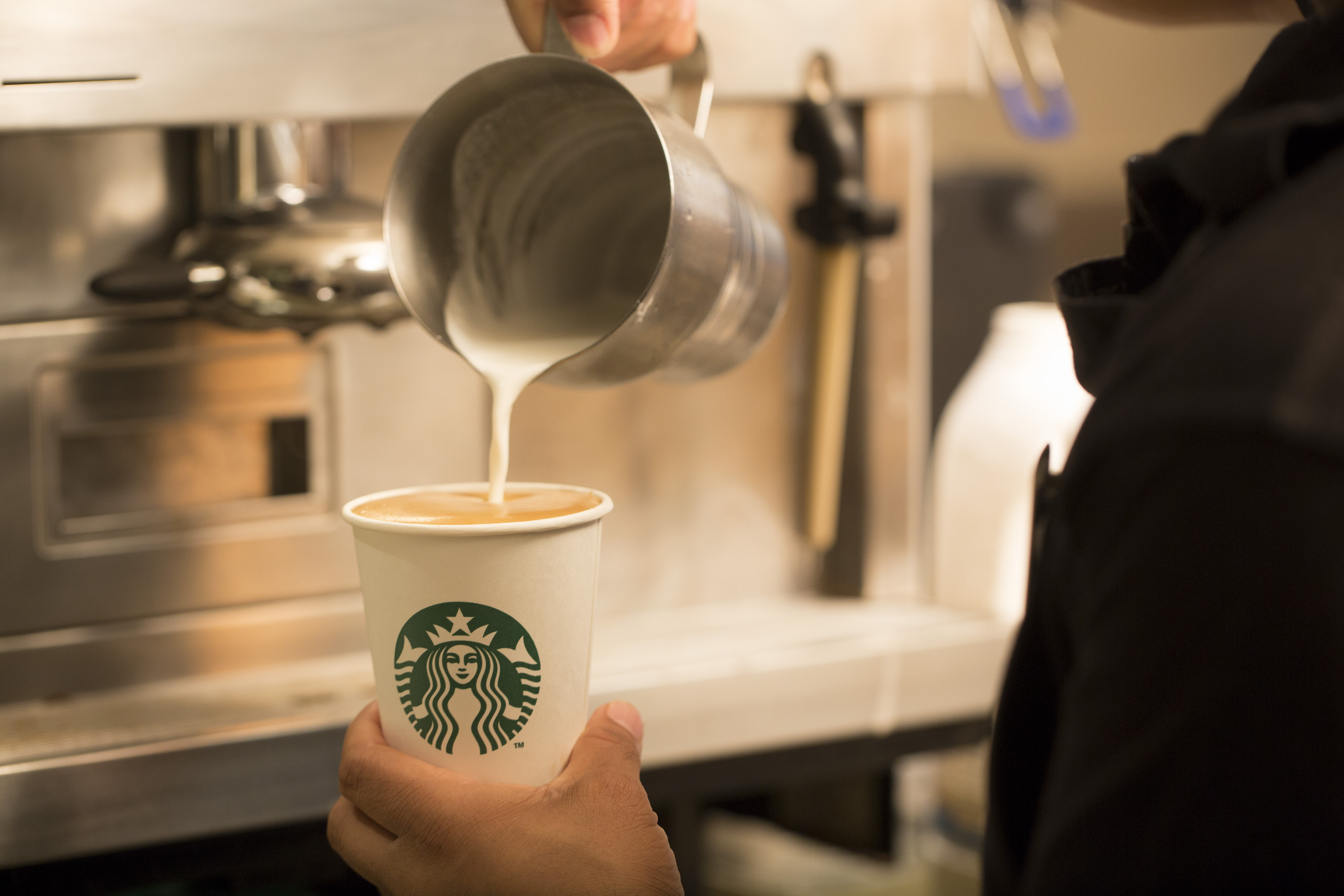 An employee pours milk into a cardboard coffee cup inside a Starbucks Corp. coffee shop in London, U.K., on Monday, Jun. 9, 2014. (Jason Alden—Bloomberg/Getty Images)