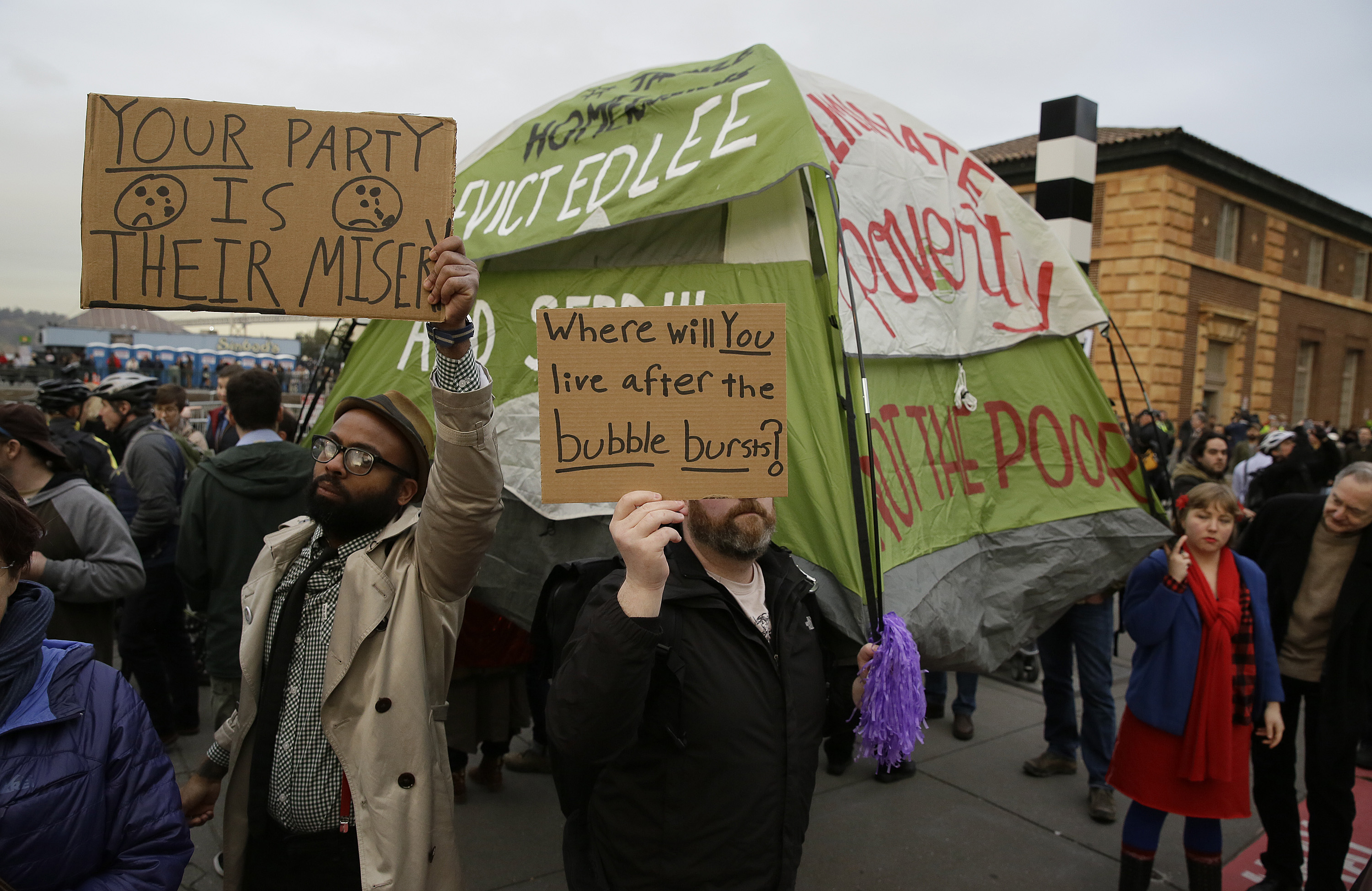People hold up signs and a tent during a protest to demand city officials do more to help homeless people outside Super Bowl City, in San Francisco on Feb. 3, 2016. (Eric Risberg—AP)