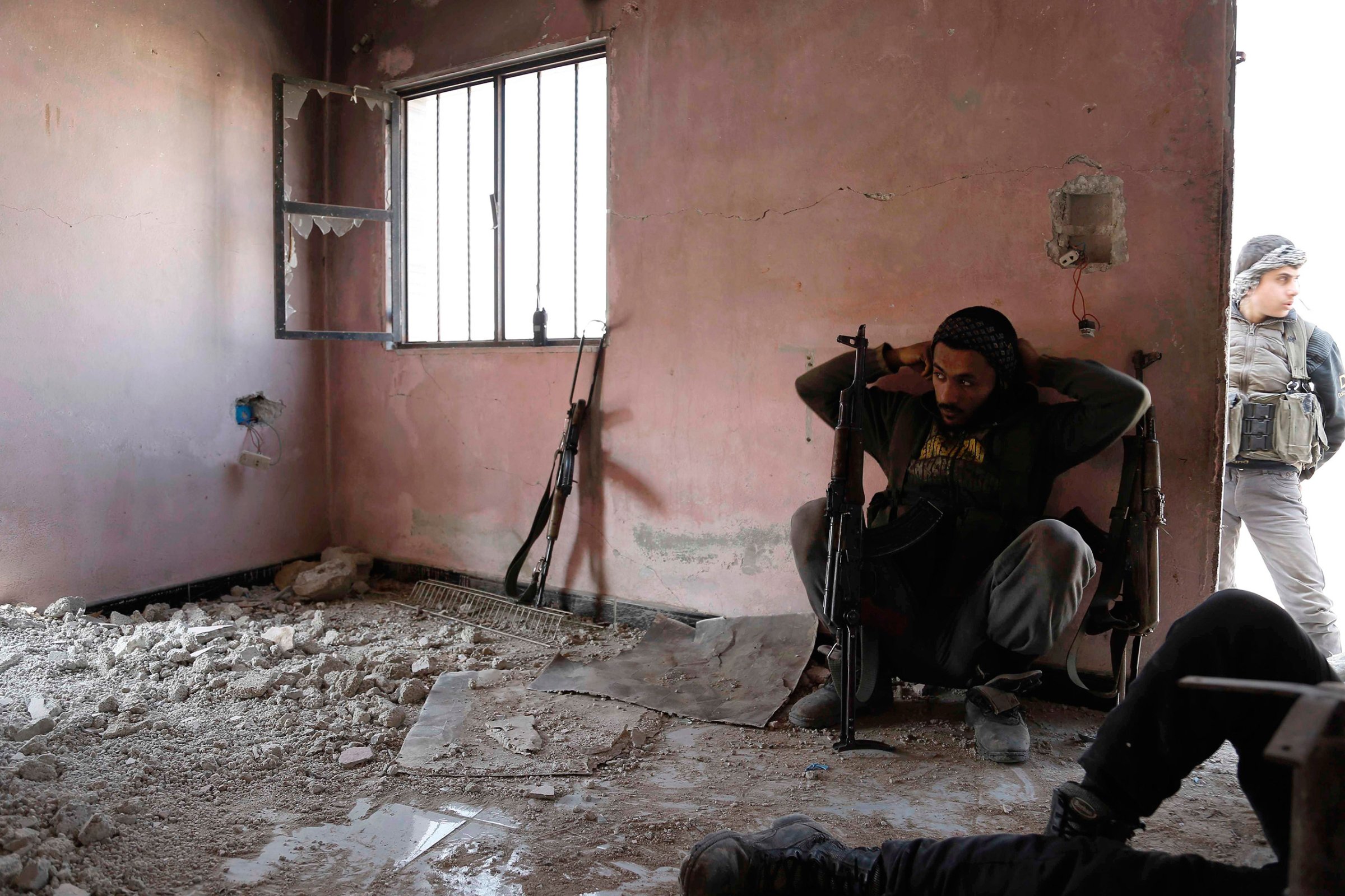 Rebel fighters from the Failaq al-Rahman brigade take a break as they hide inside a building on the frontline against regime forces in the rebel-controlled village of Bala, on the outskirts of Damascus, Syria, Feb. 28, 2016.