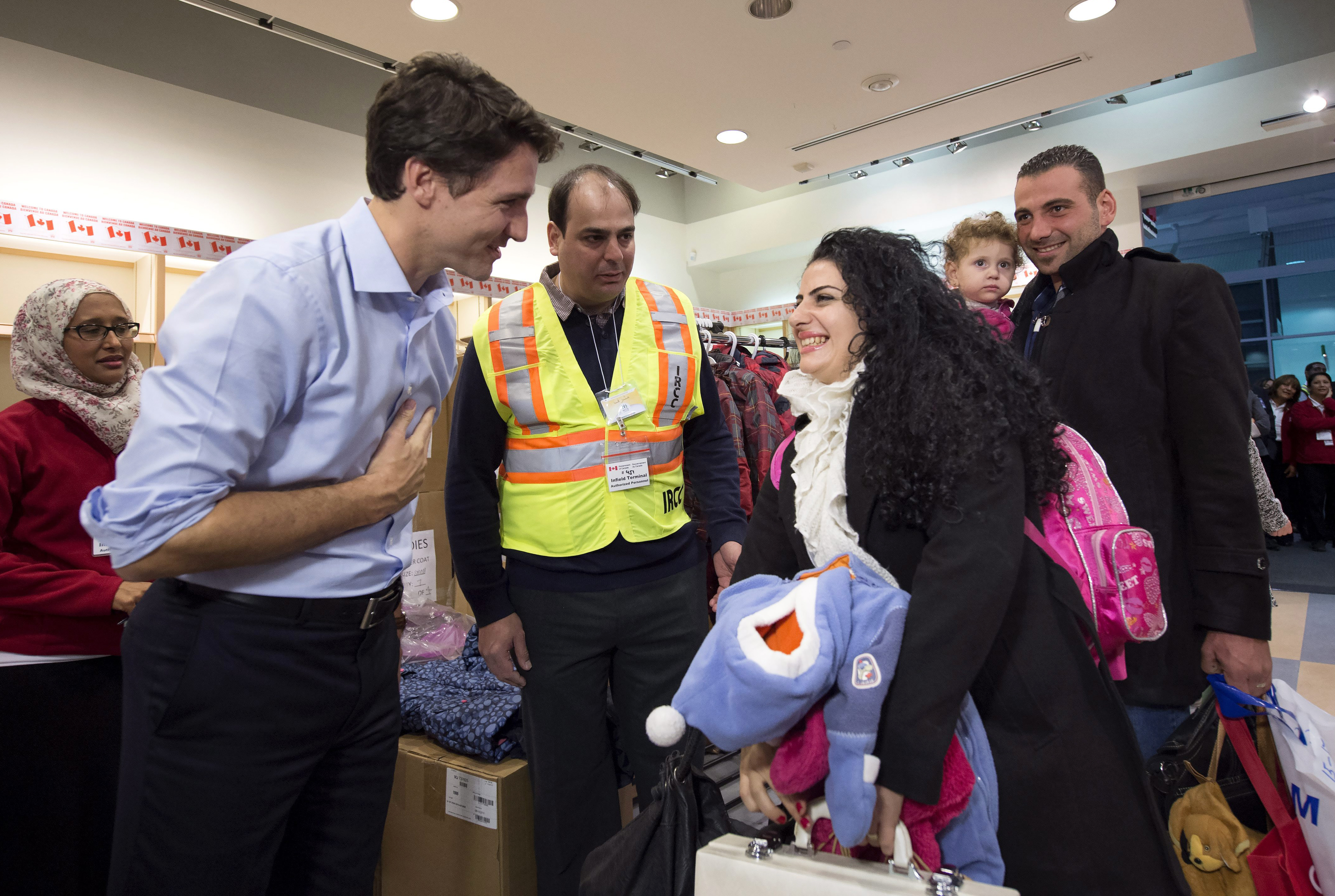 ustin Trudeau greets refugees fleeing from Syria, as they arrive at Pearson International airport, in Toronto, on Dec. 11, 2015. (Nathan Denette—AP)