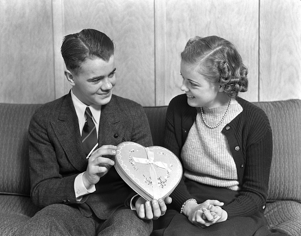 Circa 1930s:  smiling teen couple sitting on a sofa (H. Armstrong Roberts—Retrofile/Getty Images)