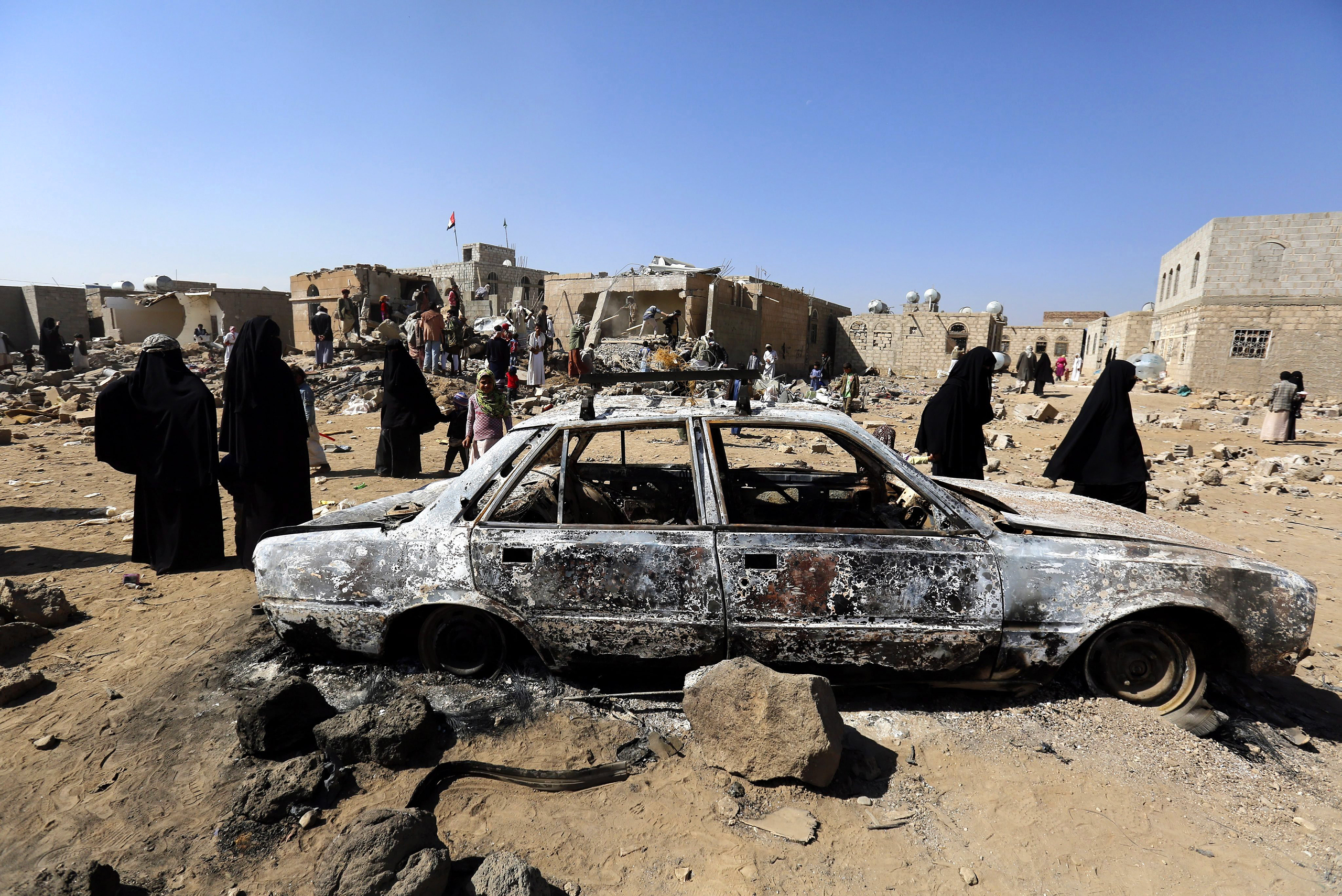 Yemenis inspect the site of a Saudi-led air strike in the city of Sana‘a on Feb. 1 (YAHYA ARHAB—EPA)