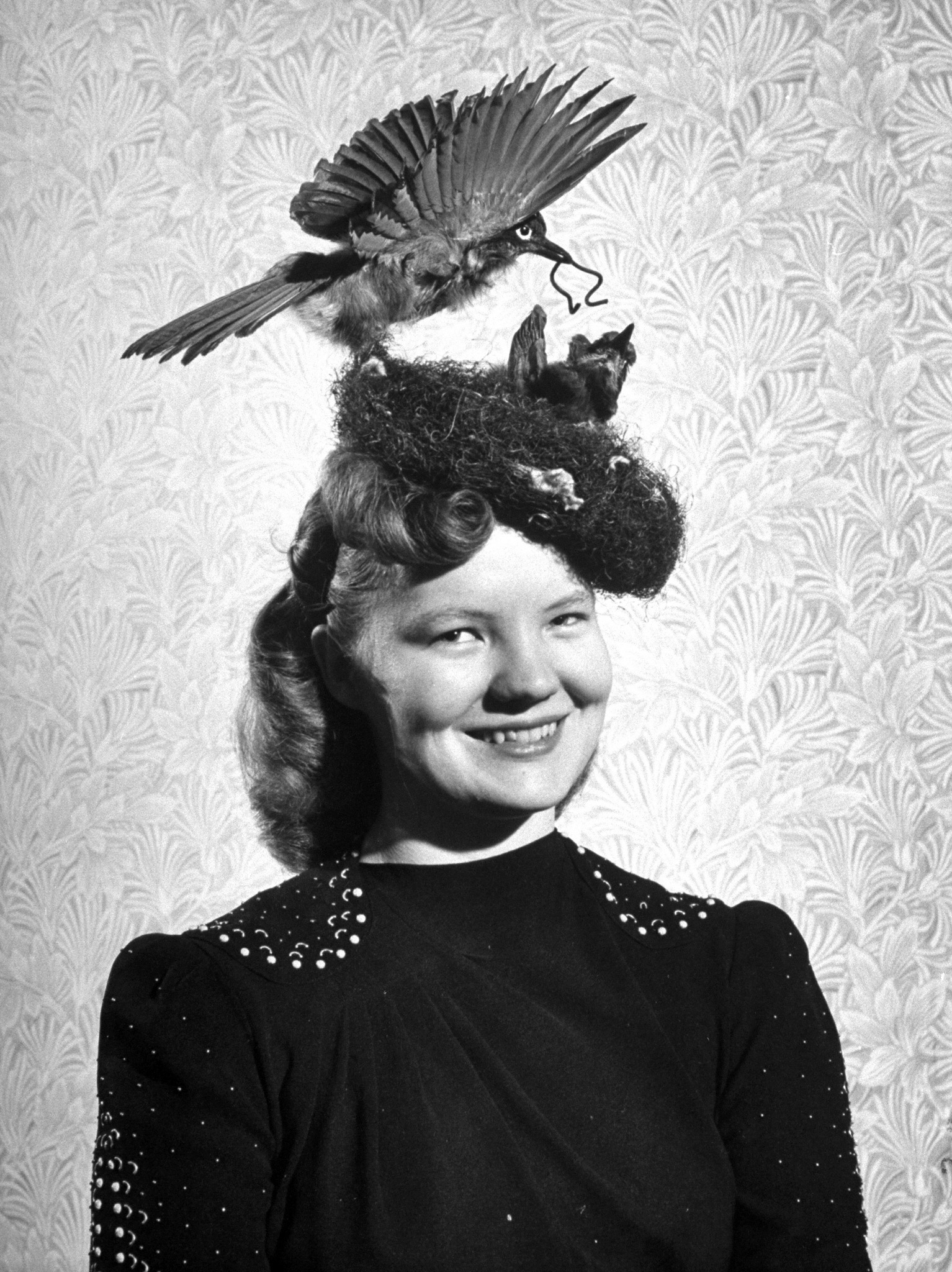 Model Marjorie Henderson, wearing feather hat designed by bride Barbara O. Ehrhart. 1947.