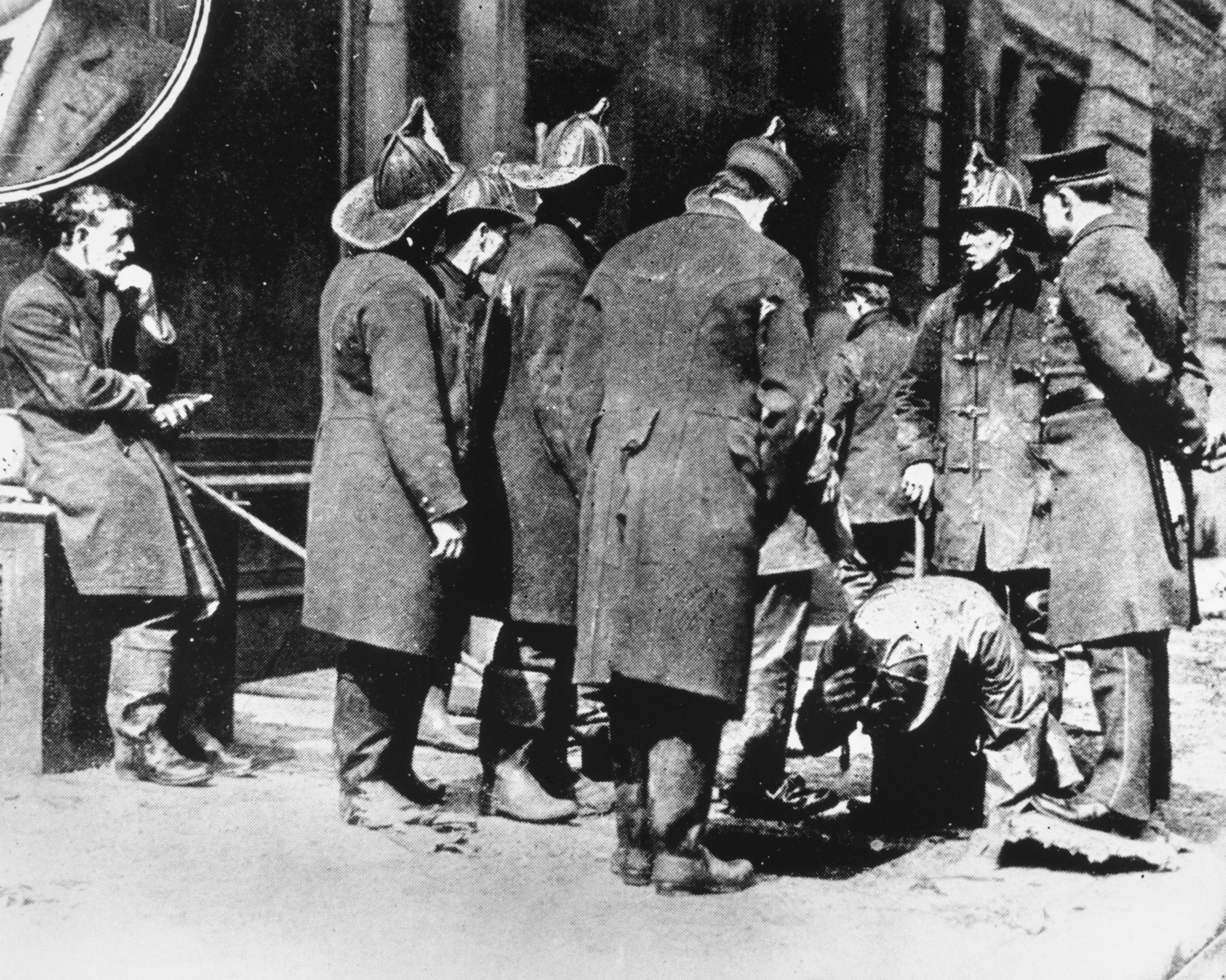 On March 25, 1911, 146 immigrant garment workers were killed after they were trapped on the upper floors of the Asch Building after the Triangle Shirtwaist Factory caught fire. The owners of the factory had chained shut the exit doors, and the workers, who were mostly young women, perished in the fire or died after jumping from the ten-story building. Firemen can be seen as they search for the bodies of those who crashed through the skylights and entrances of cellars in the sidewalk.