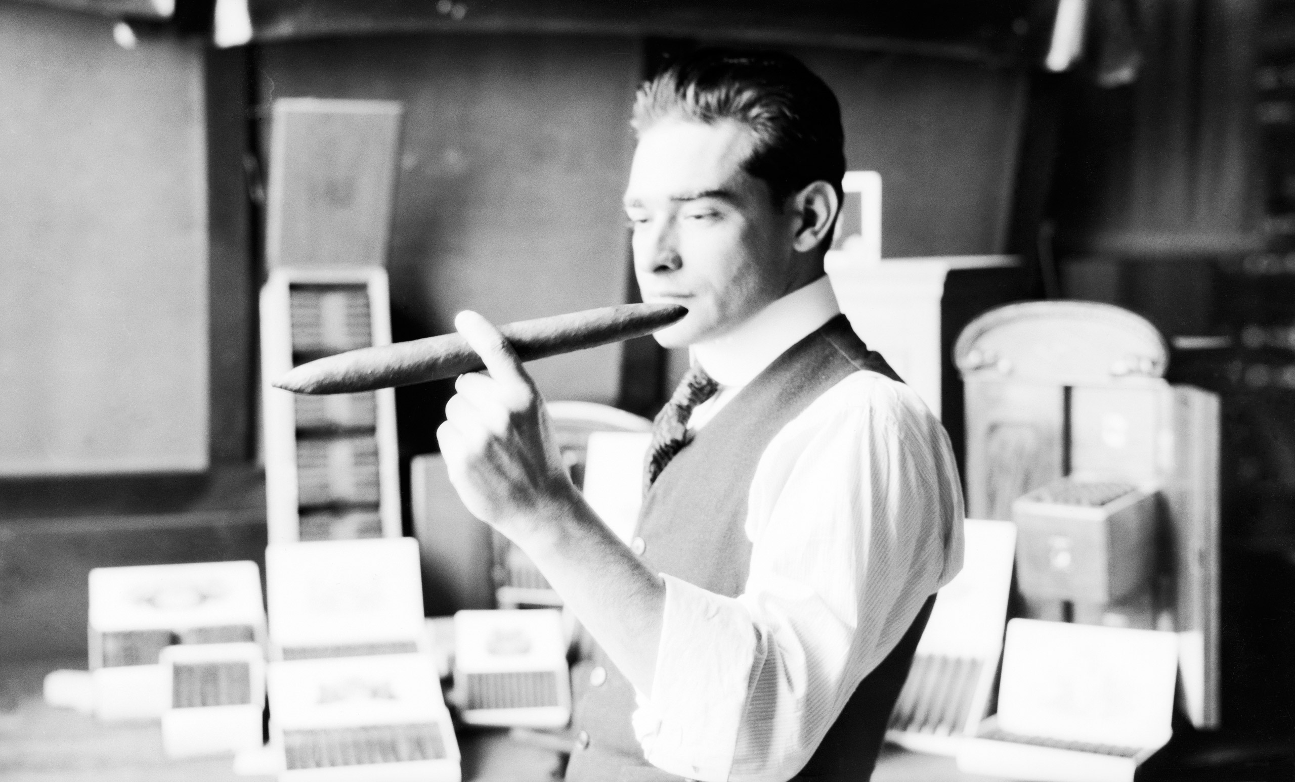 A cigar-factory employee with a large Havana Cigar. 1920.